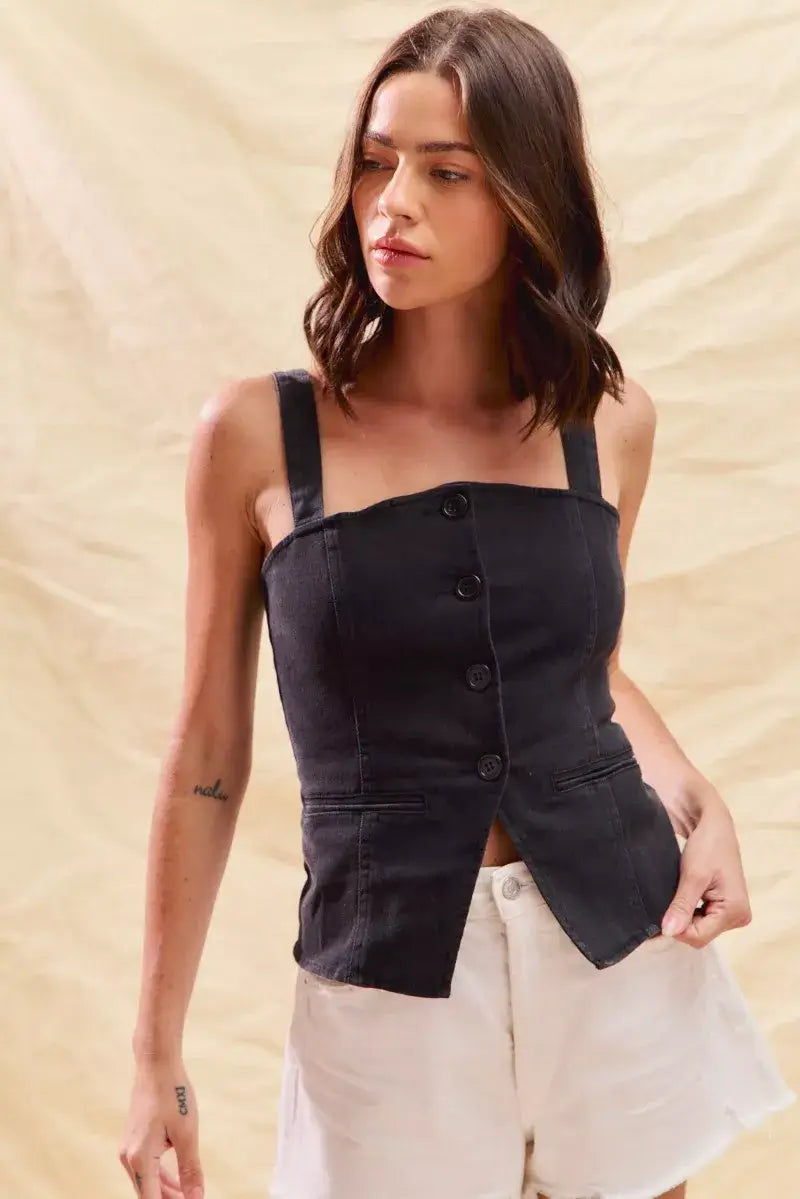 Model wearing the SO ME button down sleeveless fitted denim top, showcasing its stylish black design and button details.