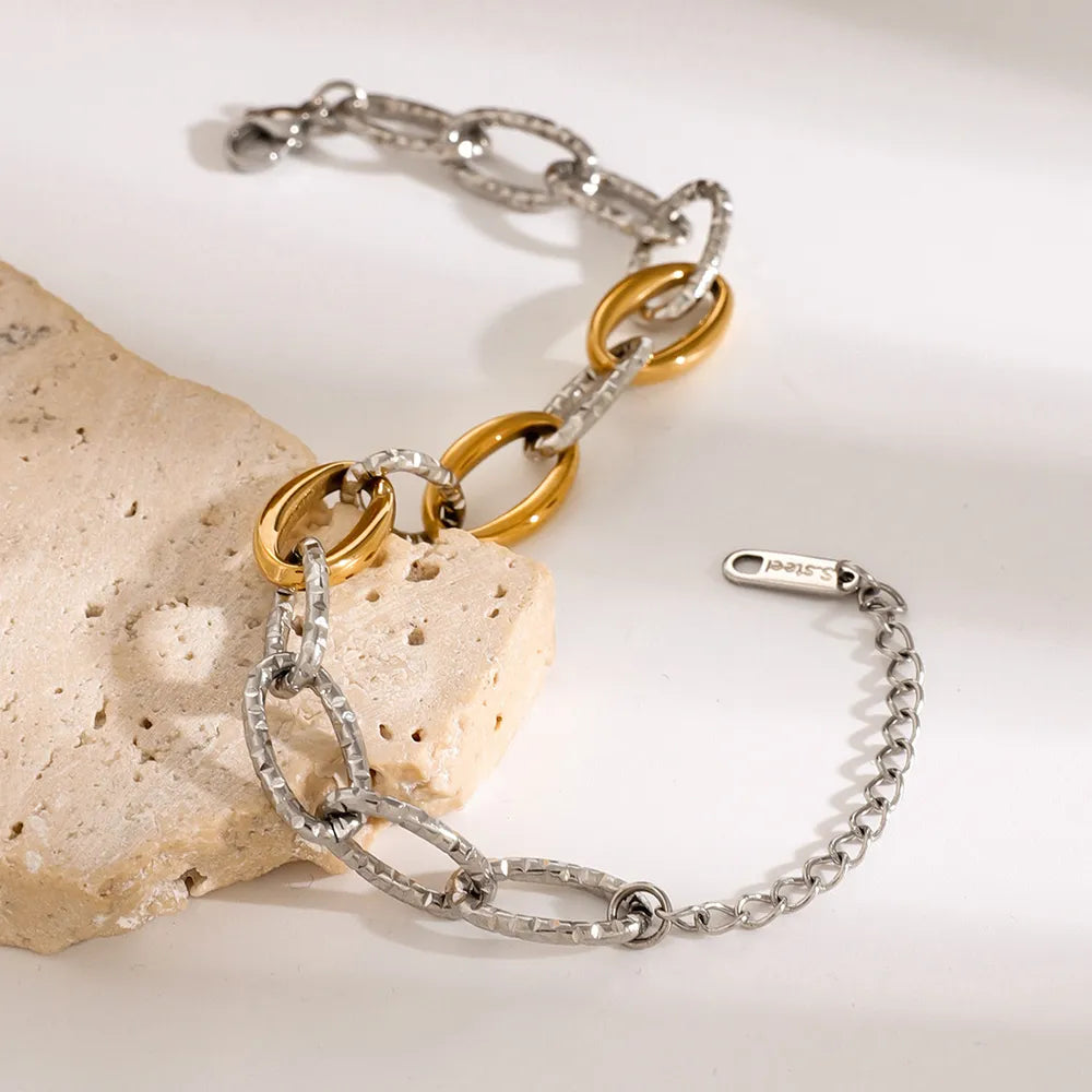 18K Gold-Plated Stainless Steel Bracelet elegantly displayed on stone, showcasing its stylish design and durability.