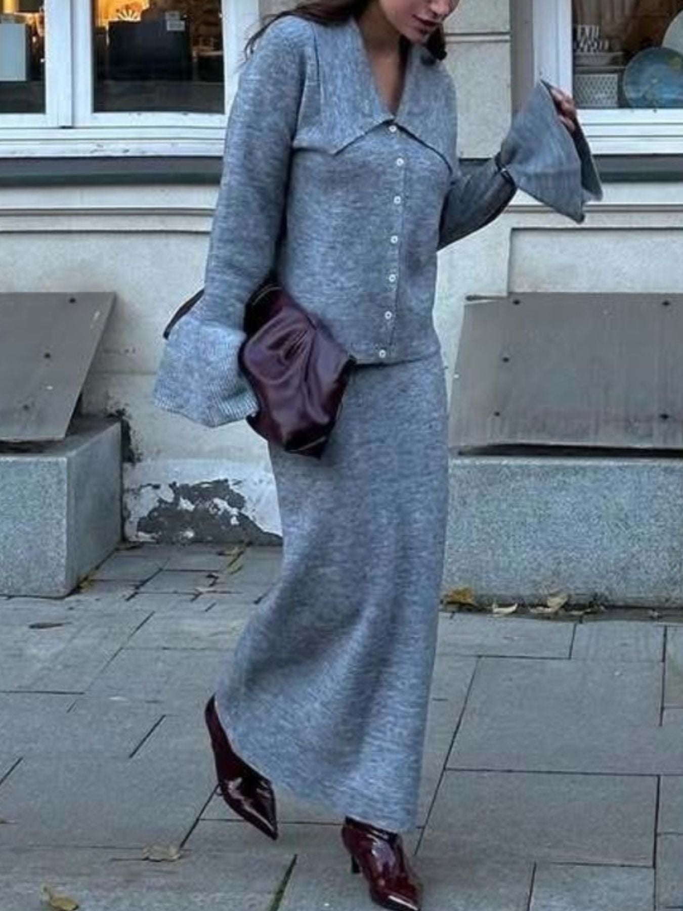Woman walking in a gray button down cardigan and skirt knit set, showcasing a stylish two piece outfit.