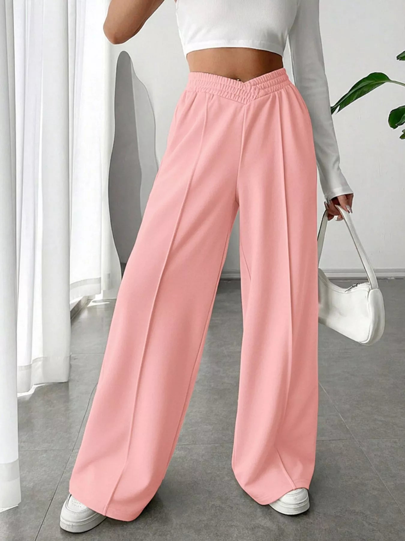 Wide Leg High Waist Pants in soft pink for an elegant everyday style, paired with a cropped white top and stylish handbag.