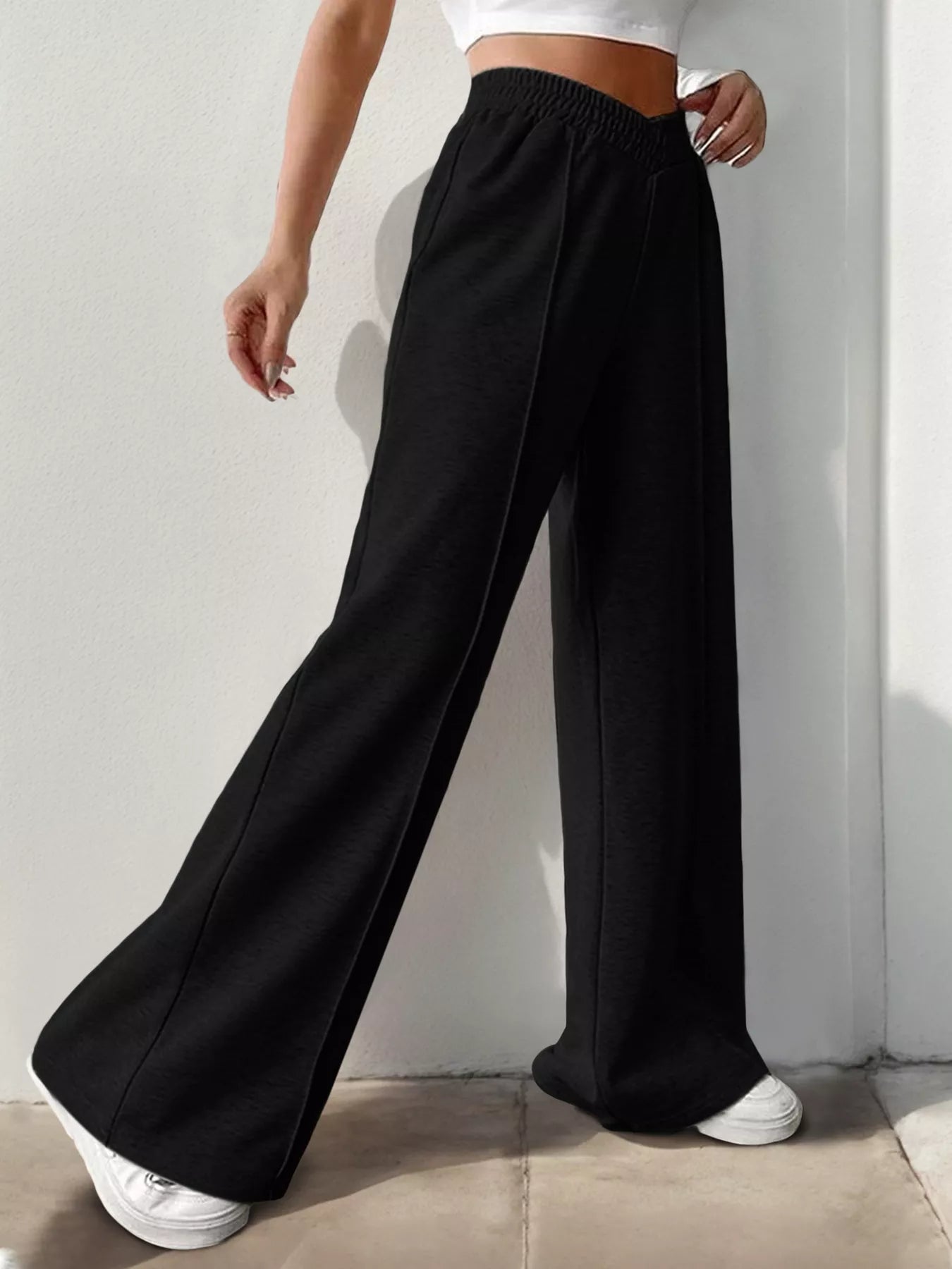 Wide Leg High Waist Pants in black, styled for elegant everyday fashion, paired with a crop top and white sneakers.