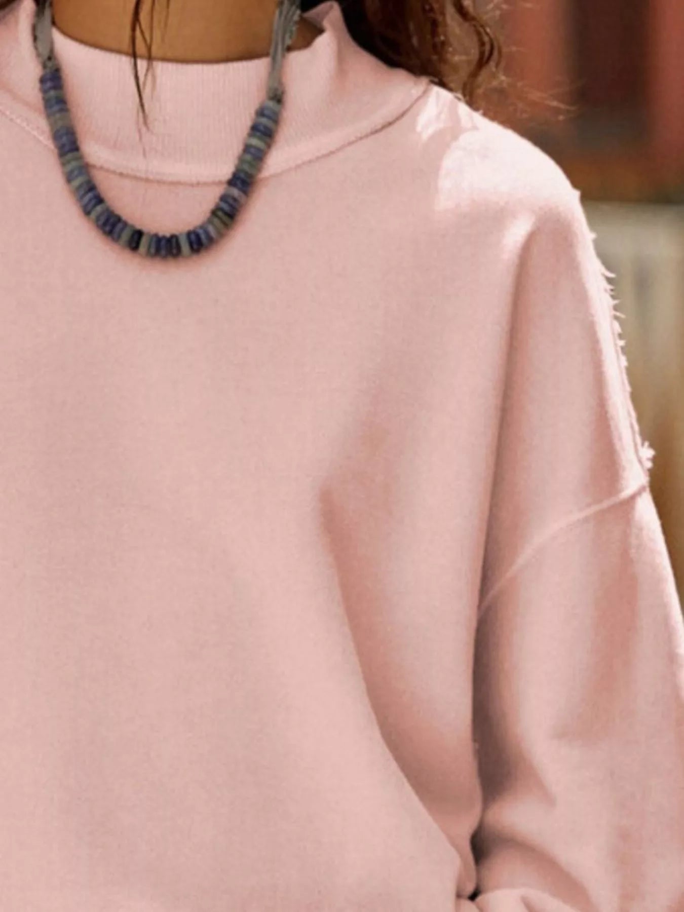 Exposed Seam Dropped Shoulder Sweatshirt in soft pink color with a neck accessory, perfect for casual wear.
