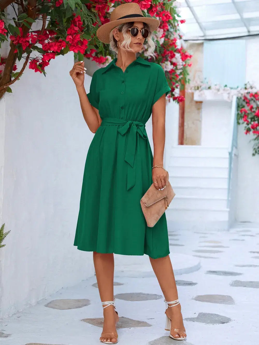 Model wearing a green Buttoned Tie Waist Short Sleeve Dress with a hat and handbag in a floral outdoor setting.