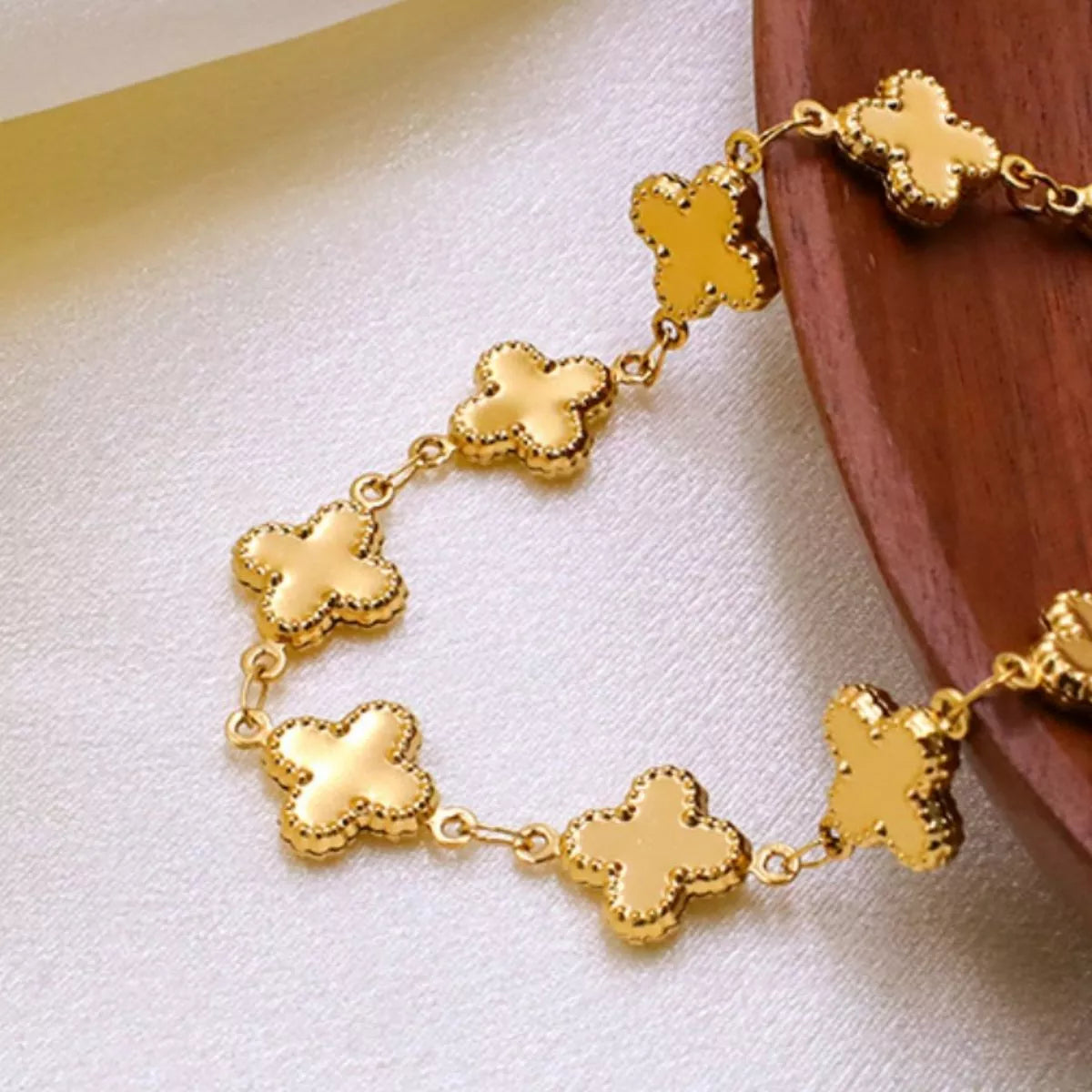 Close-up of the 18K Gold-Plated Clover Charm Necklace showcasing the clover links on a soft background.