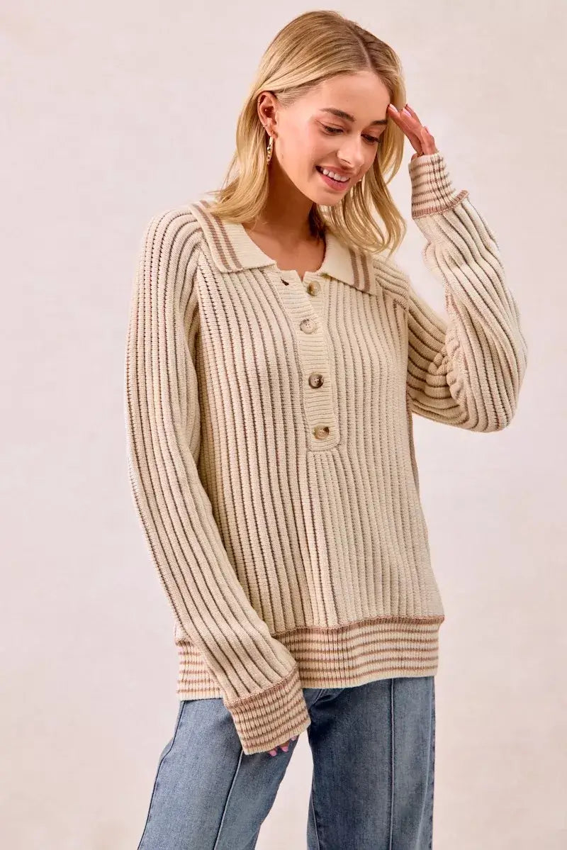 Woman wearing a BiBi half button ribbed two tone sweater, featuring a relaxed fit and button-front detail.