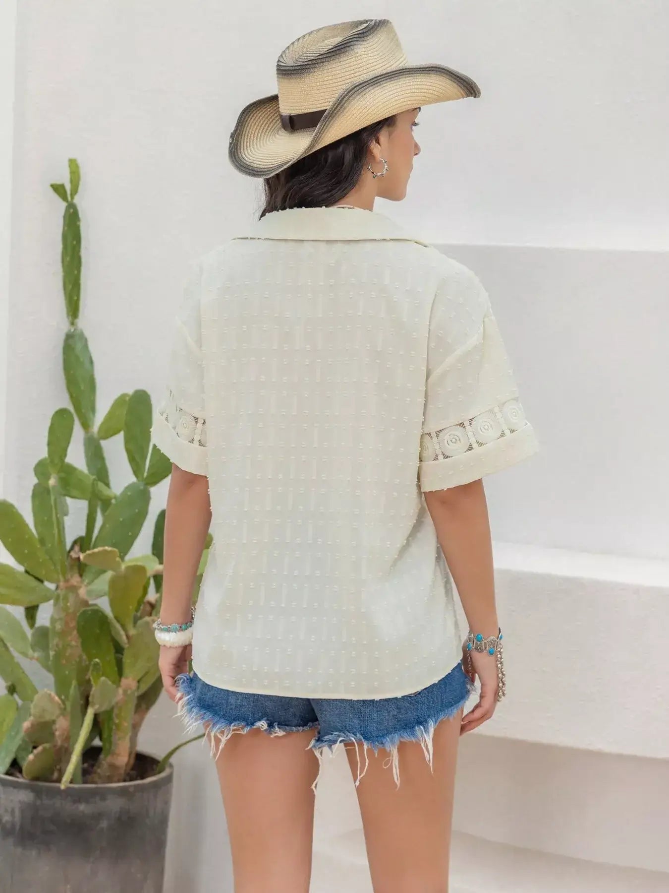 Back view of a woman in a stylish Collared Neck Half Sleeve Shirt paired with denim shorts and a cowboy hat.