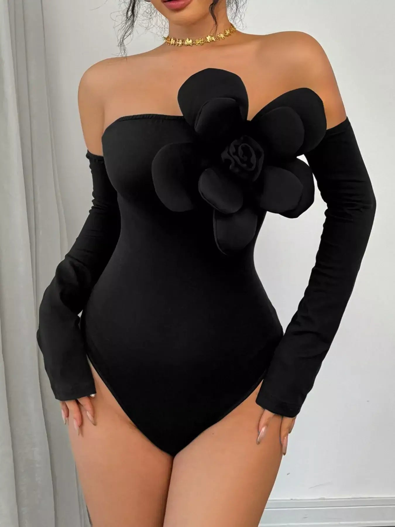 Flower off-shoulder long sleeve bodysuit in black with floral detail, featuring long fitted sleeves and an elegant silhouette.