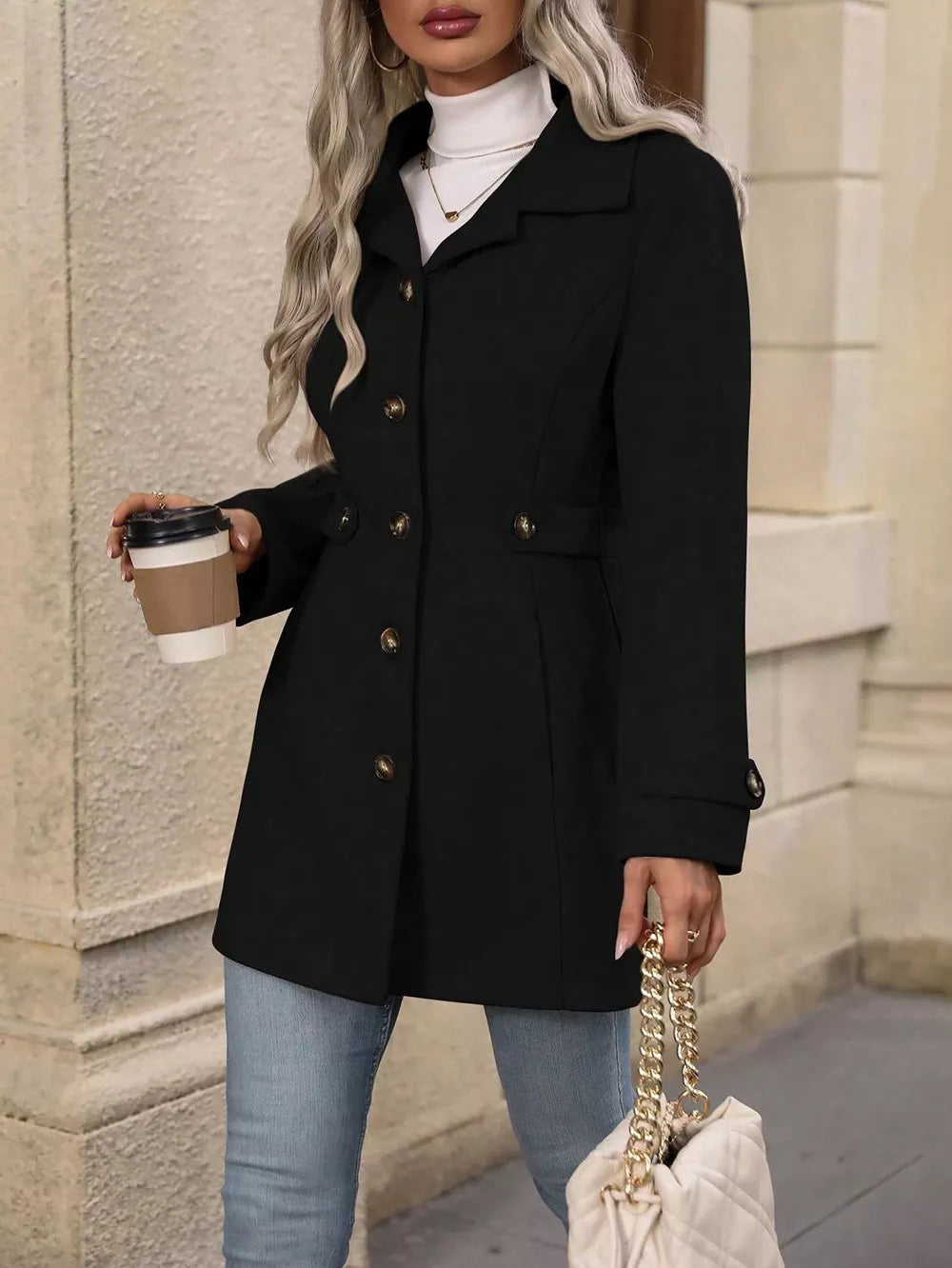 Woman wearing a Collared Neck Button Up Coat, holding a coffee, styled with a turtleneck and jeans.