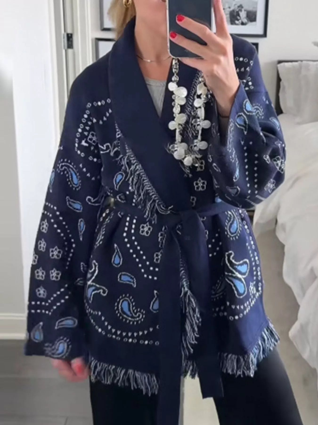Model wearing a Printed Fringe Long Sleeve Cardigan with blue paisley print and fringe details.