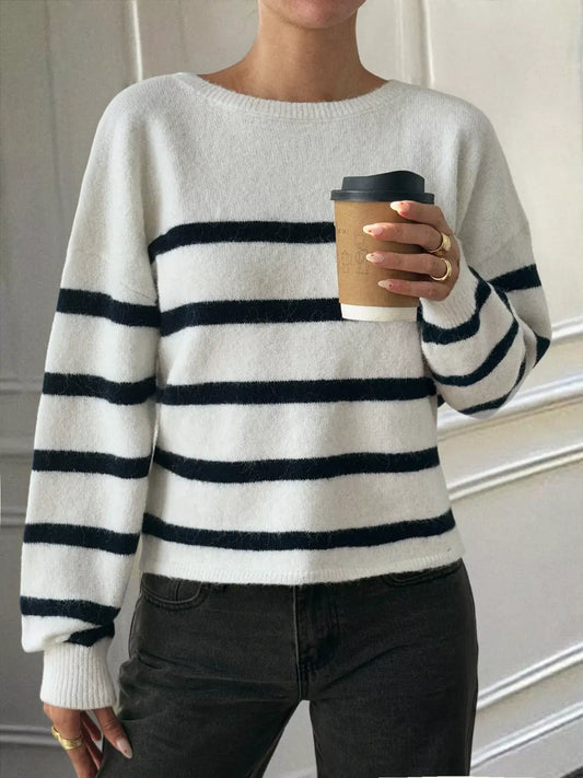 Striped round neck long sleeve knit top in white and navy, paired with a coffee cup for a casual chic look.