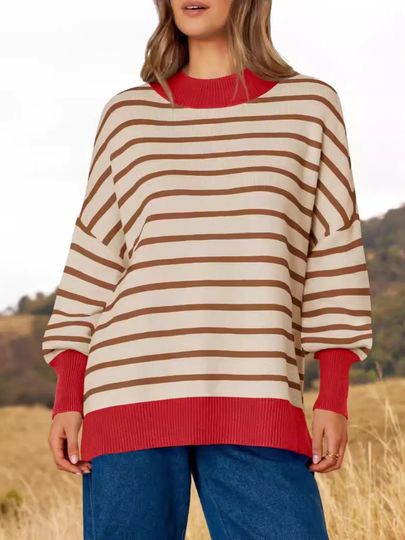 Model wearing Striped Round Neck Long Sleeve Sweater with oversized fit and red accents in a natural setting.