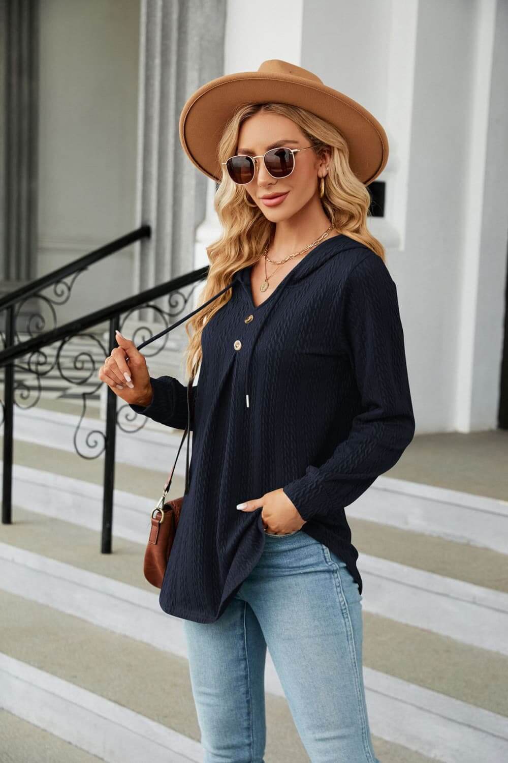 Casual look featuring a woman wearing a Long Sleeve Hooded Blouse, stylish hat, and sunglasses, showcasing comfort and style.