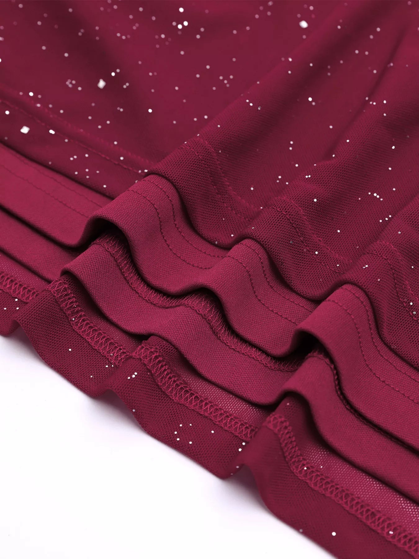 Close-up of the fabric details of the Glitter Off-Shoulder Maxi Dress featuring a stretchy burgundy design with glitter.