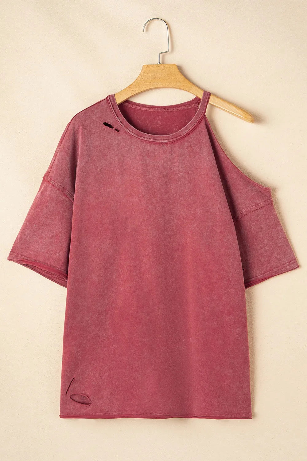 One Shoulder Half Sleeve Oversized Tunic T Shirt for Women in distressed pink color hanging on a wooden hanger.