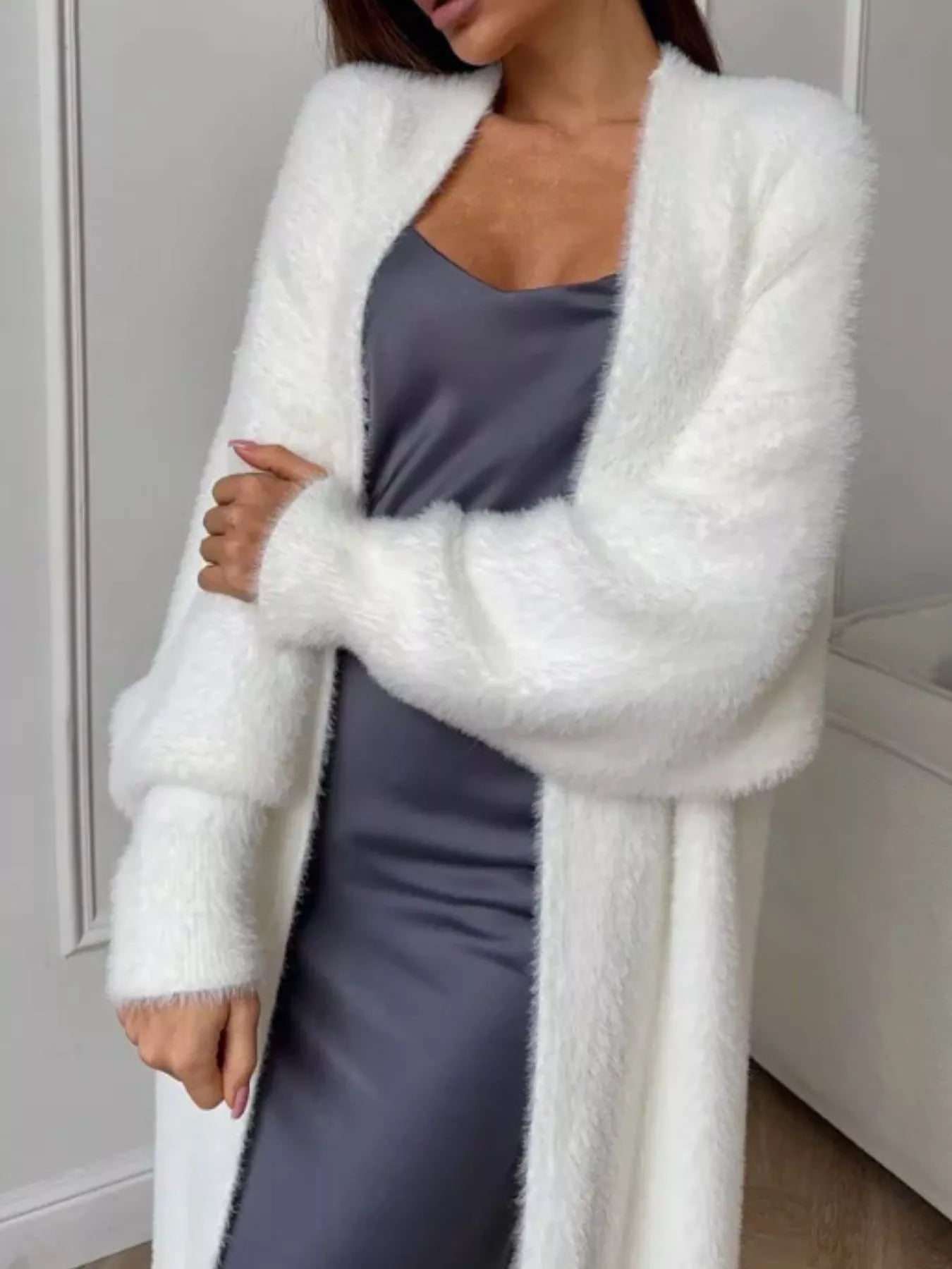 Cozy woman wearing Fuzzy Open Front Longline Cardigan over a gray dress for stylish warmth.