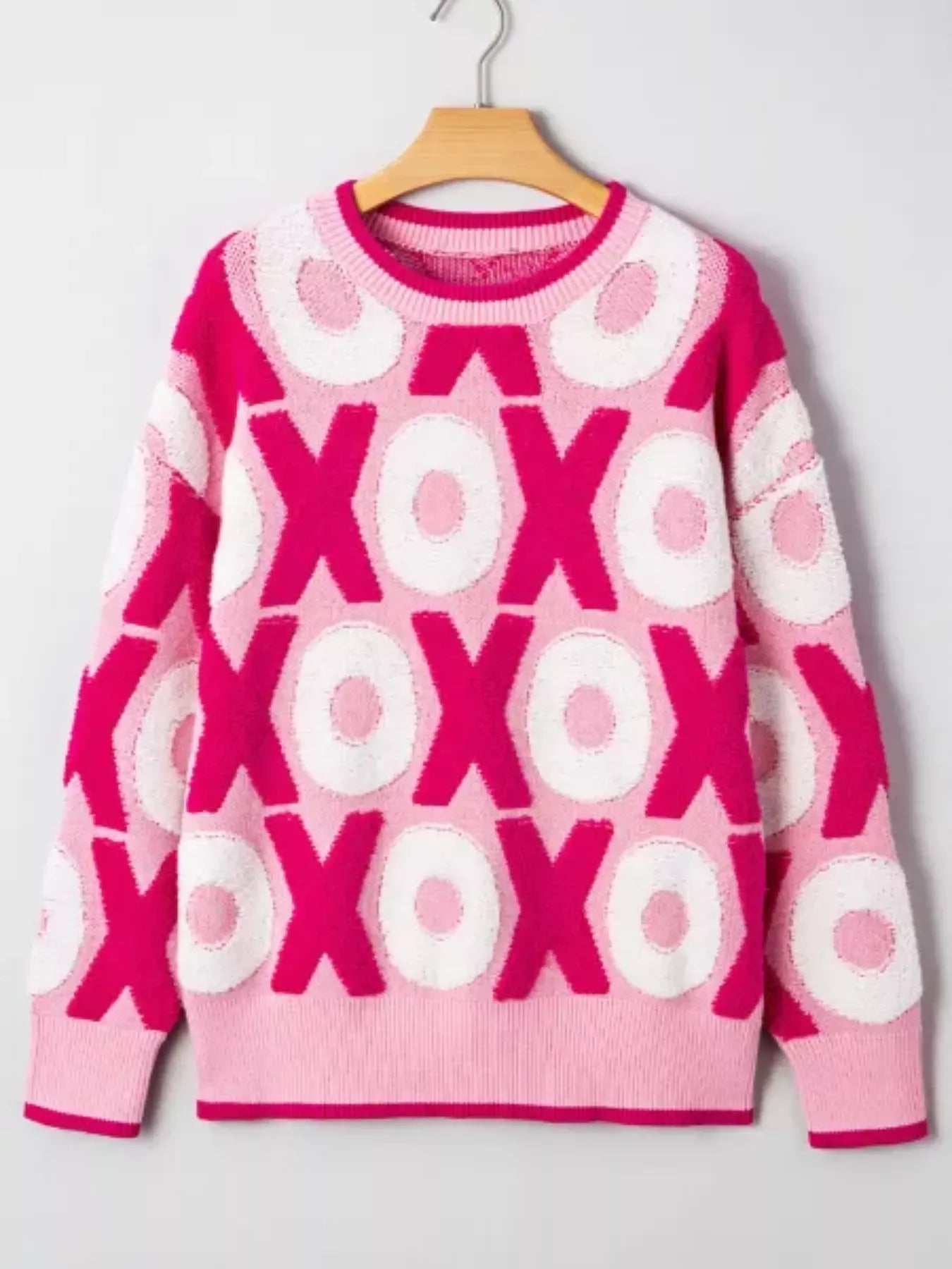 XOXO Pattern Round Neck Sweater showcasing a vibrant pink design with playful XOXO motifs.