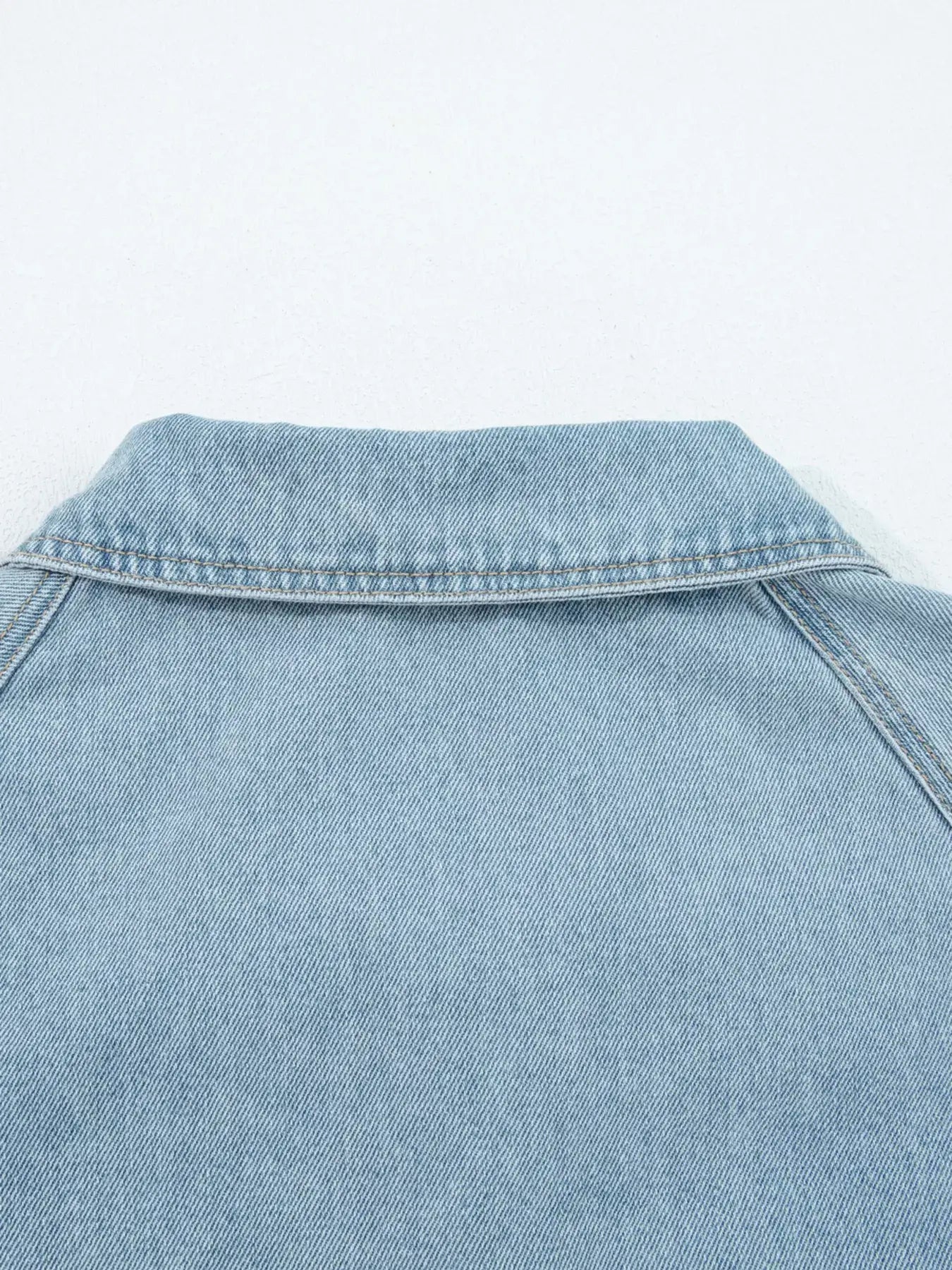 Close-up of the collar of an Elastic Edge Collared Zip Up Denim Jacket, showcasing its stylish design and soft denim fabric.
