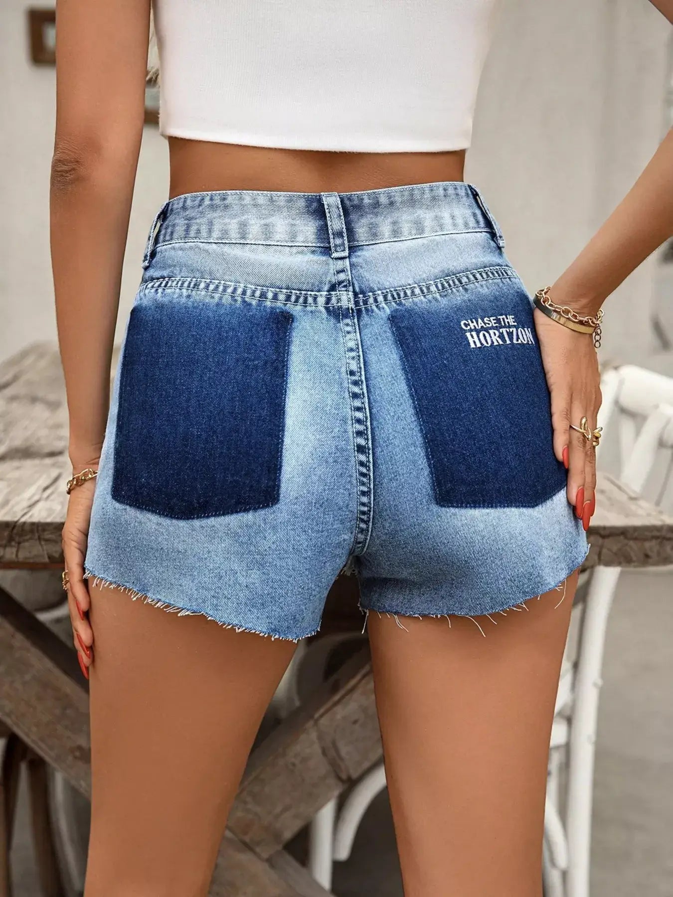 Back view of women's raw hem denim shorts with distressed wash and trendy design, perfect for summer casual wear.