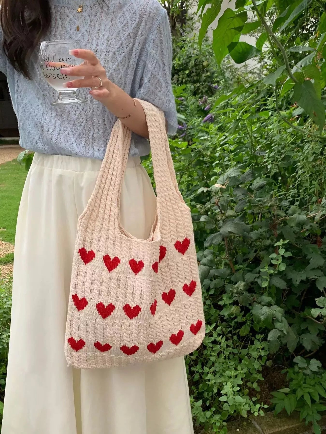 Heart Pattern Knitted Handbag held by a woman, featuring a pink design with red hearts, suitable for everyday casual style.