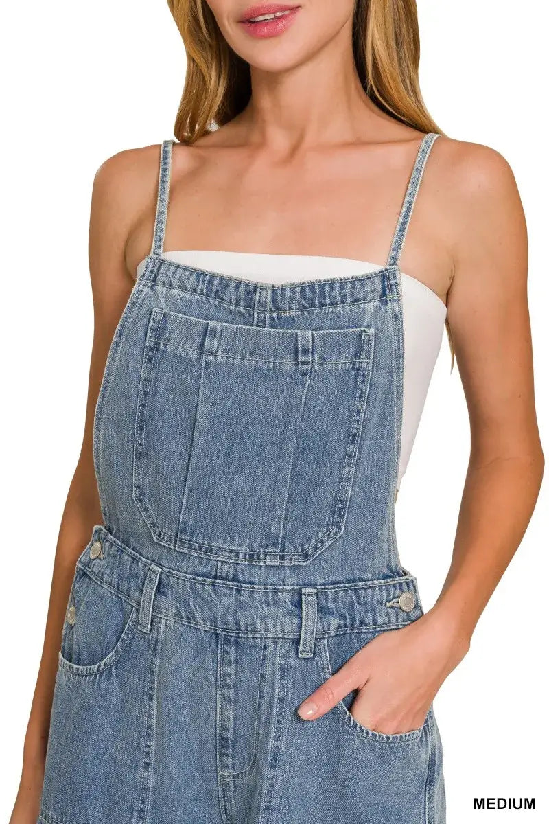 Close-up of a woman wearing Zenana Denim Wide Leg Overalls in medium wash with a white top underneath.