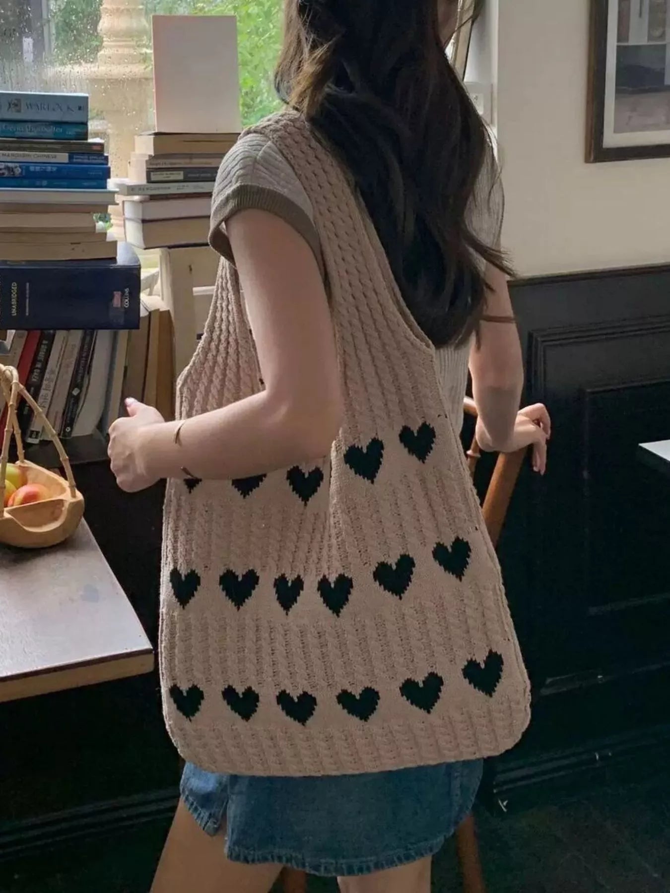Heart Pattern Knitted Handbag showcased on a model in a casual setting, featuring black hearts on a beige background.