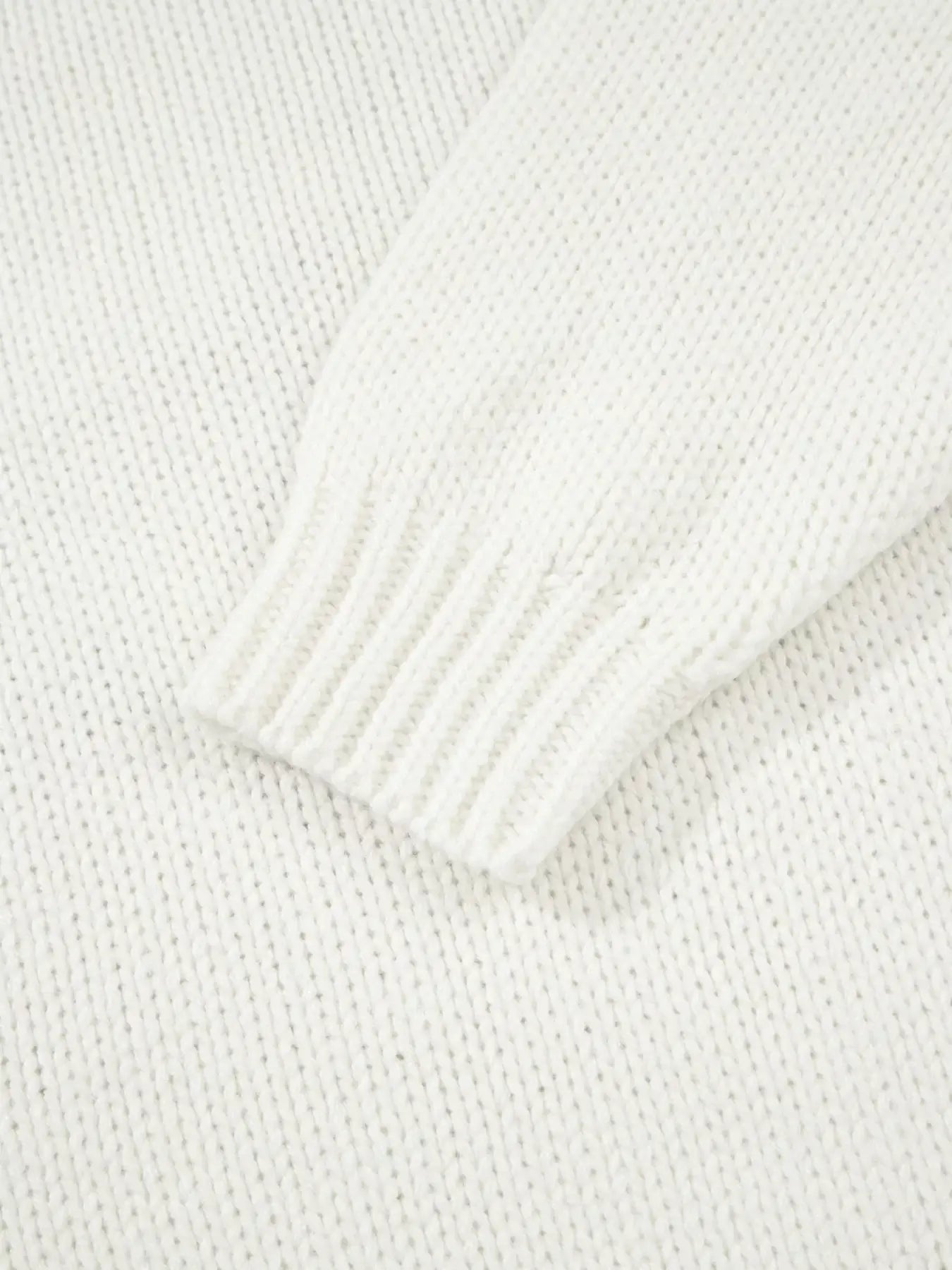 Close-up of sleeve detail showcasing the texture of the embroidered bow boots graphic drop shoulder sweater.
