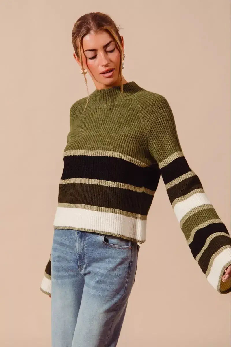 Model wearing SO ME multi color striped mock neck sweater with multicolor stripes and stylish sleeves.