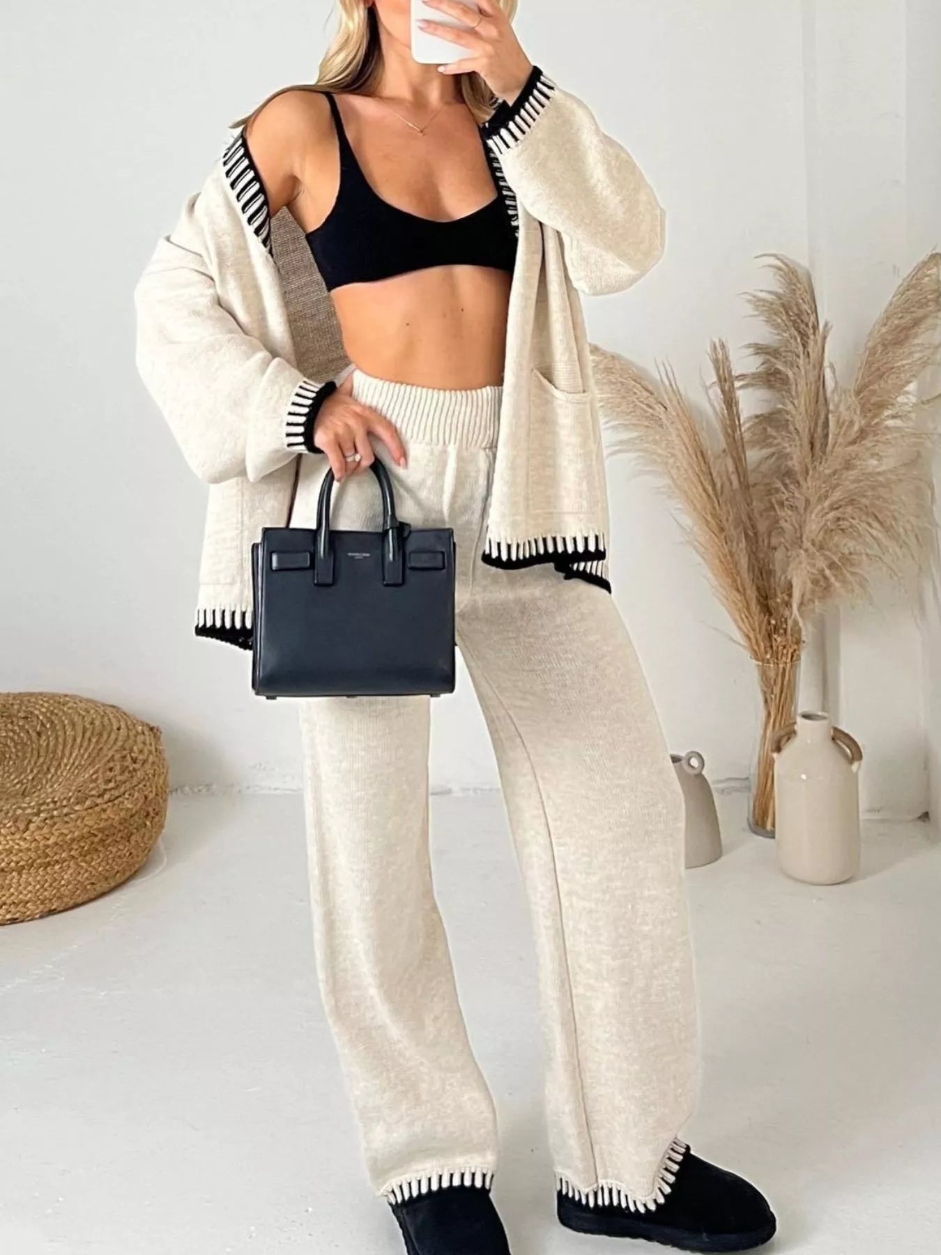 Model wearing a Button Up V-Neck Cardigan and Pants Sweater Set with a black top and a small handbag.
