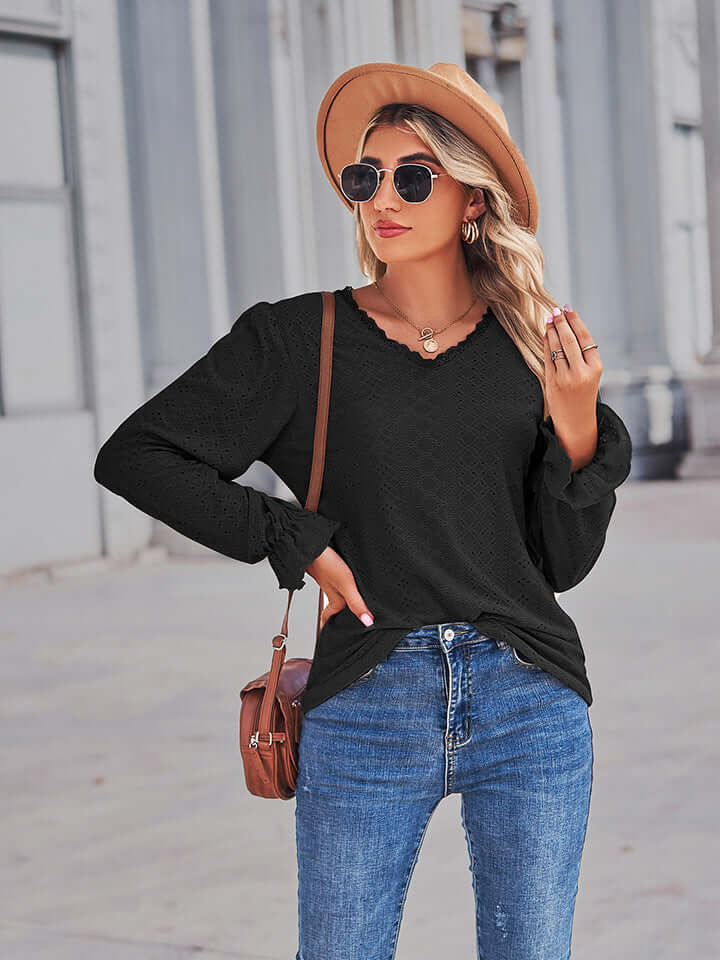 Woman wearing Eyelet V-Neck Flounce Sleeve Blouse with flounce sleeves and a V-neck, styled with a hat and sunglasses.