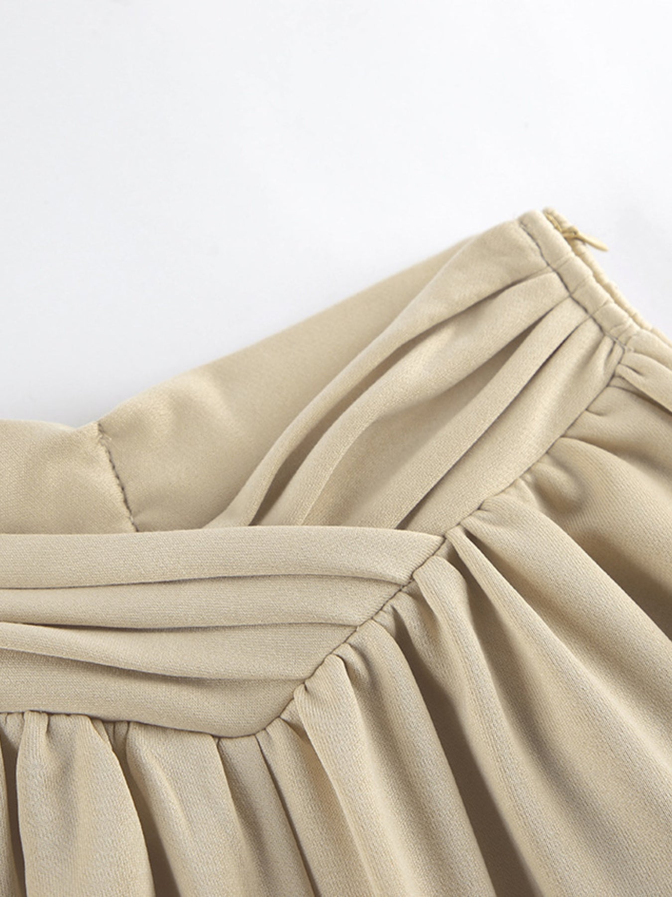 Close-up of the Round Neck Top and Wide Leg Pants Set showing pleats and zipper detail in beige fabric.