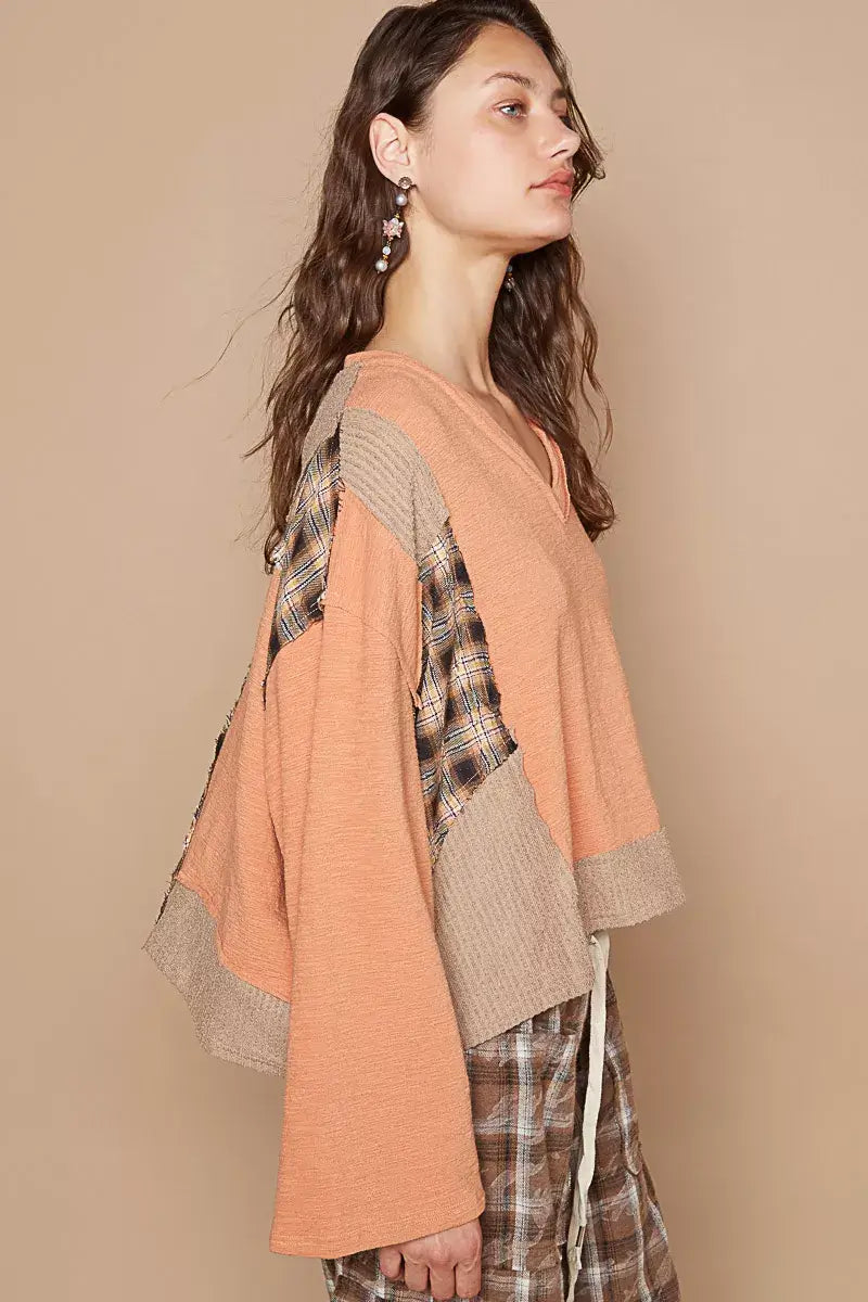 POL V-Neck Long Sleeve Plaid Contrast Top with Texture Knit Detail, featuring an orange hue and unique patchwork design.