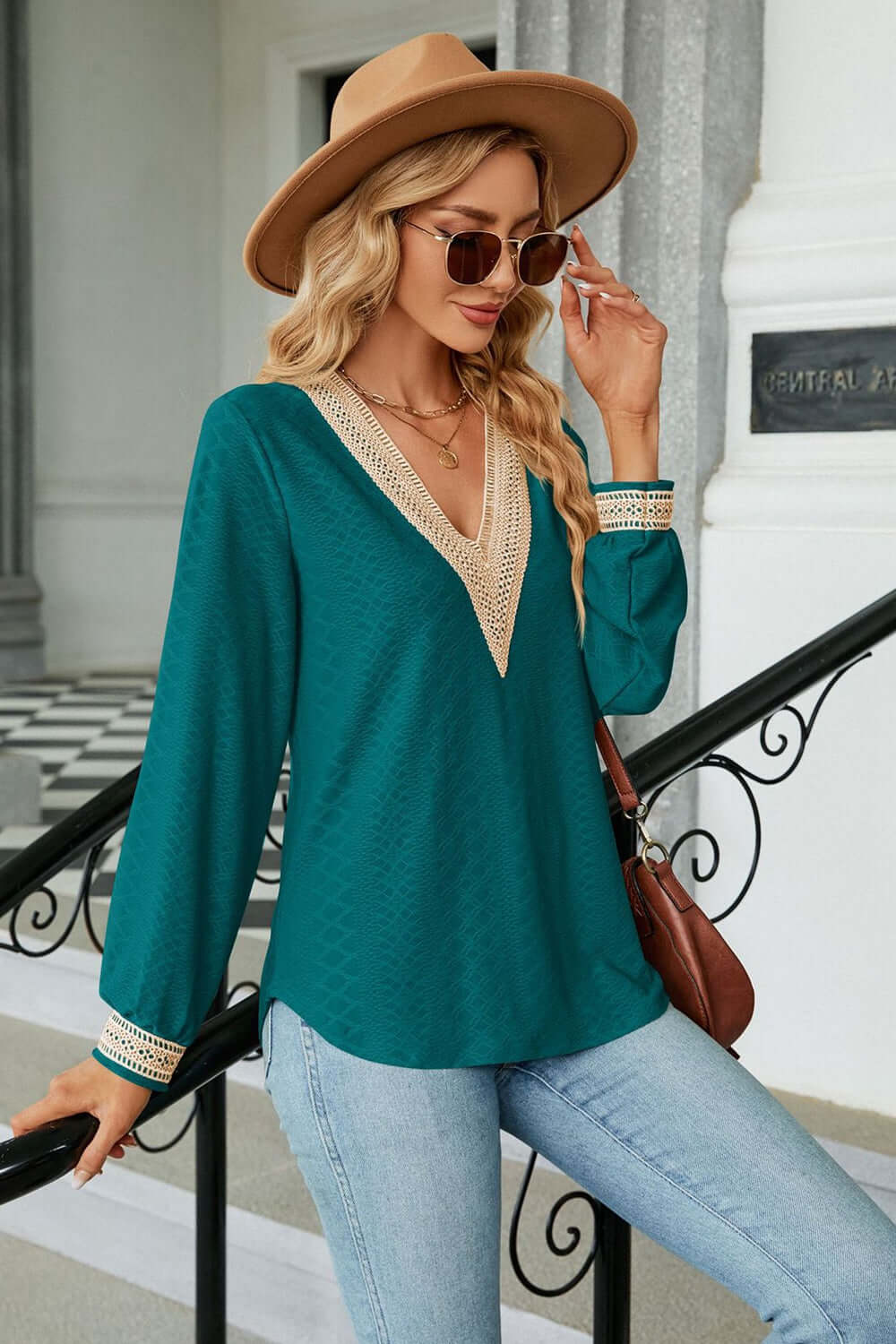 V-Neck Long Sleeve Blouse in teal worn with a hat and sunglasses, showcasing casual elegance and stylish details.
