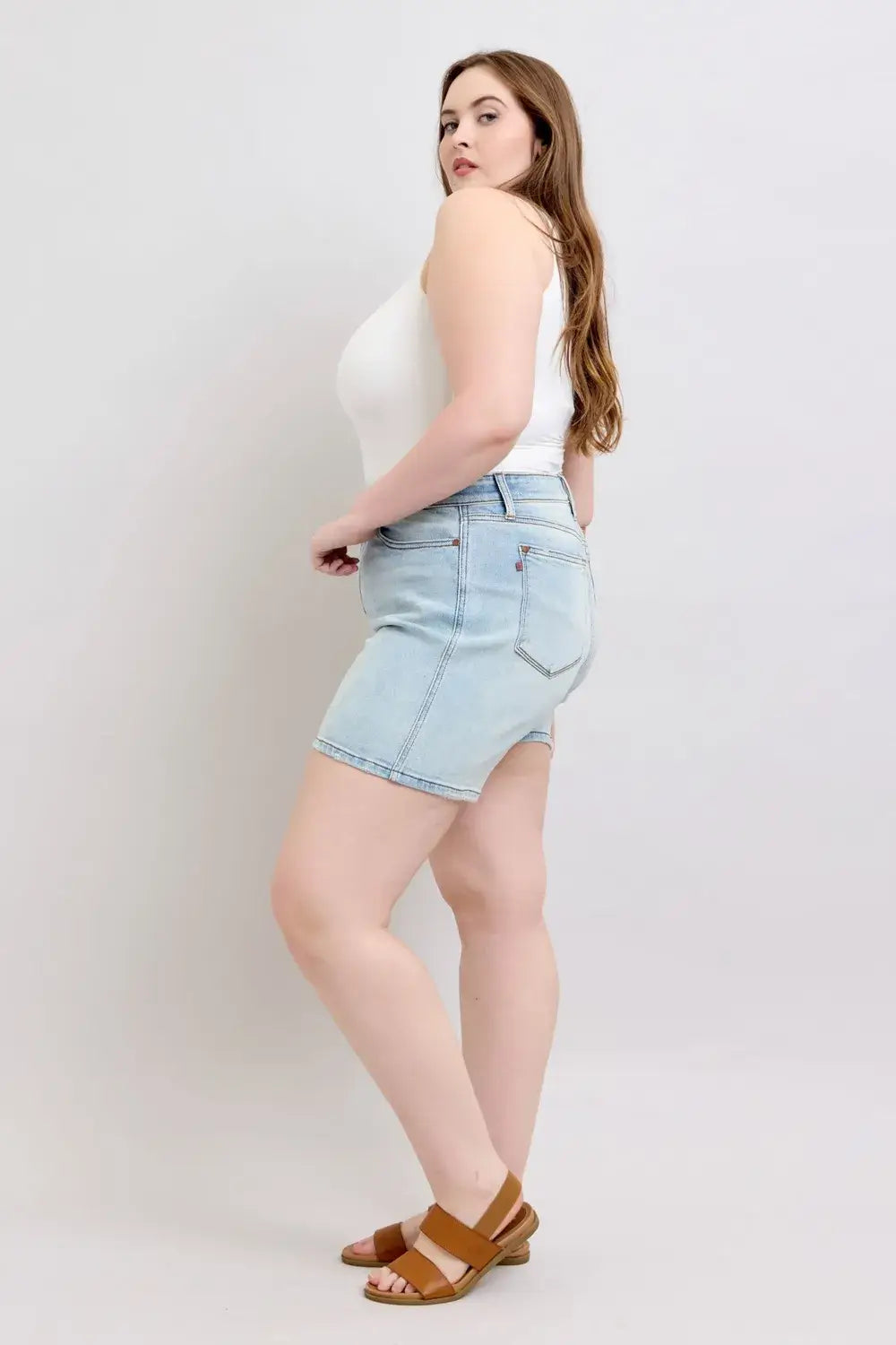 Plus size model wearing Judy Blue denim shorts with 2 buttons and pockets, styled with a white tank top.