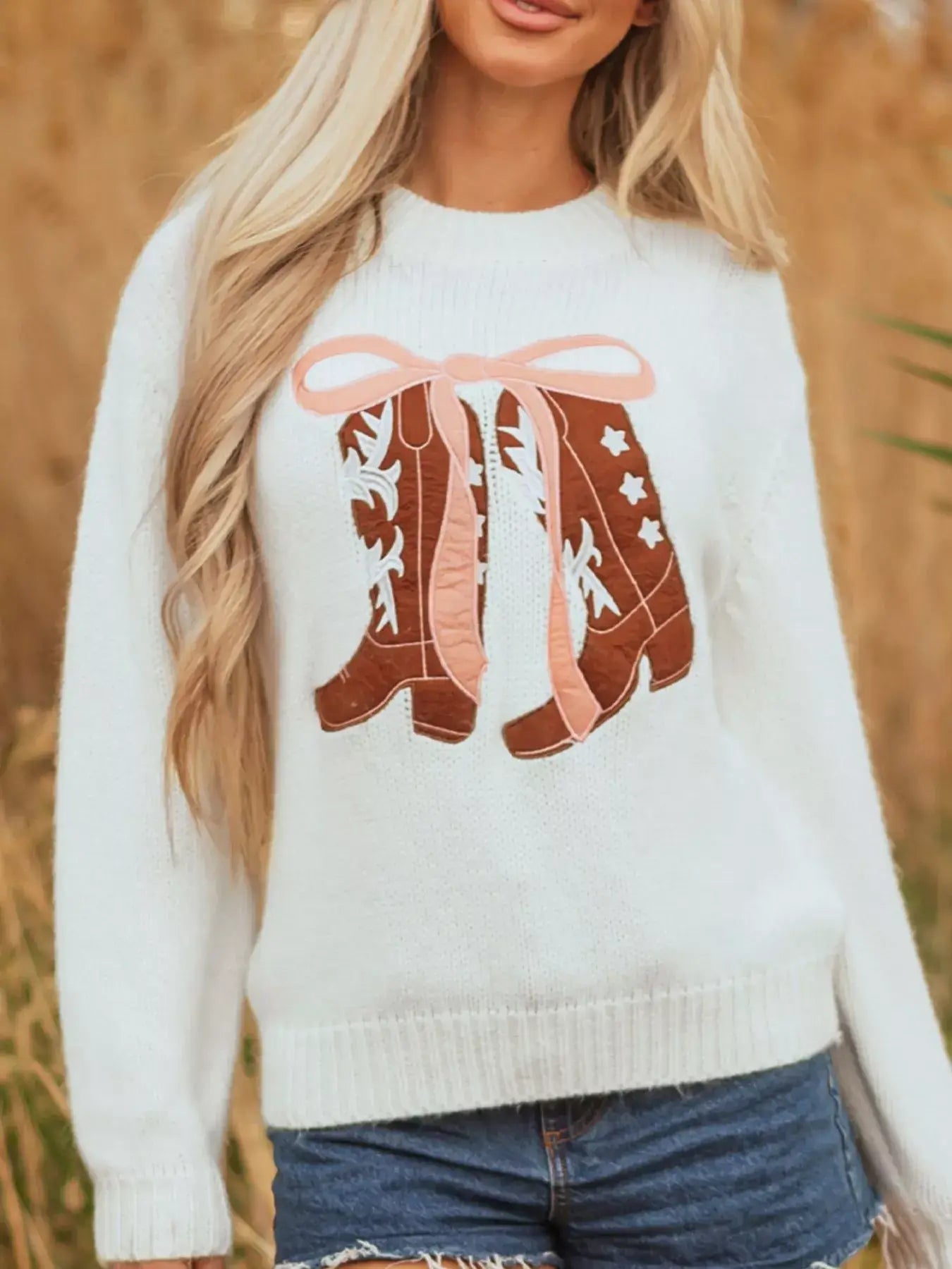 Embroidered bow boots graphic drop shoulder sweater in cozy knit style with playful design of boots and bows.