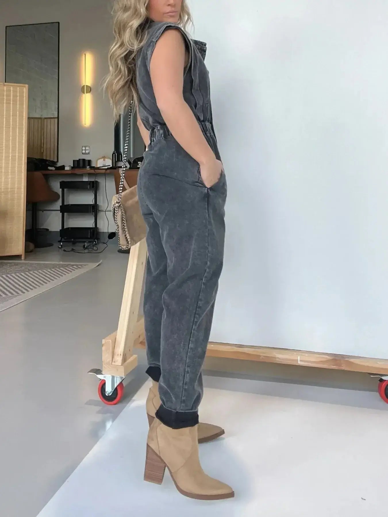 Model showcasing a full size button front cap sleeve denim jumpsuit plus size with beige ankle boots.