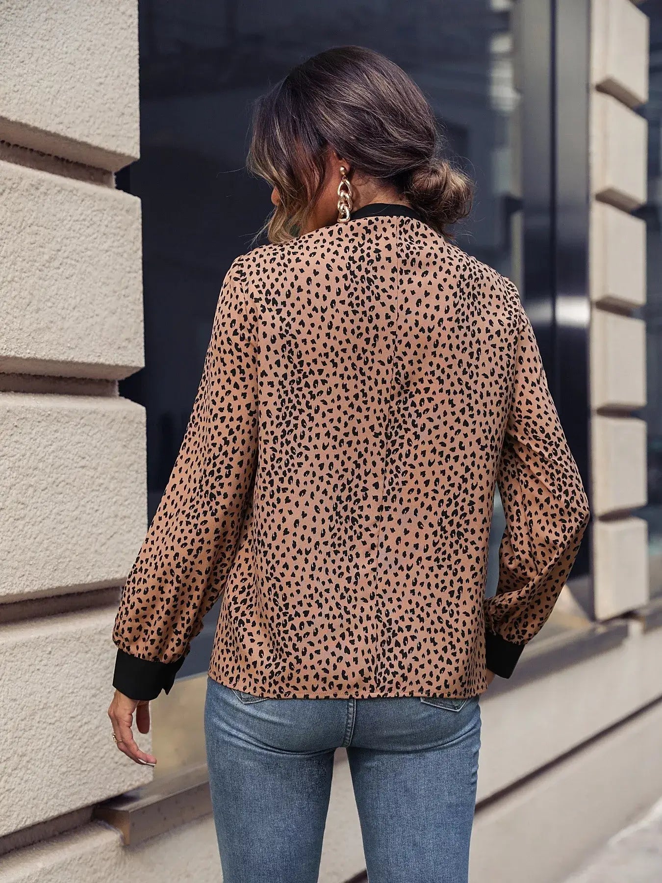 Animal print contrast trim tie front blouse shown from the back, featuring a chic design and stylish detailing.