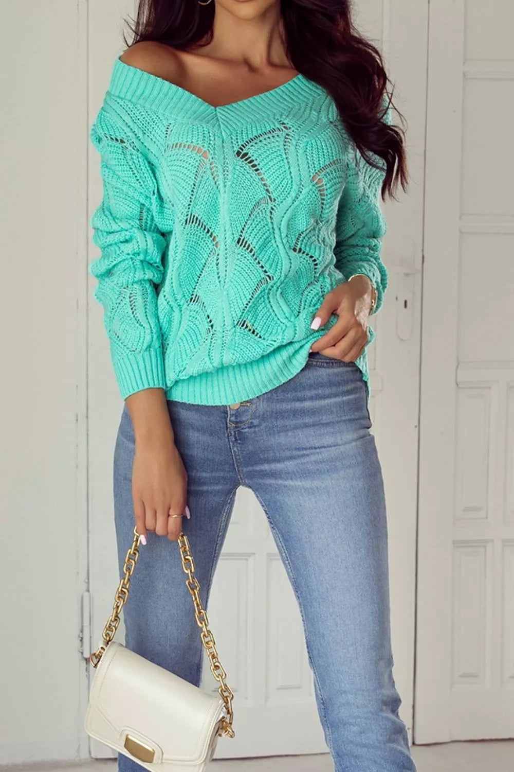 Elegant Texture V-Neck Knit Top worn by a woman in a turquoise cable knit sweater with a chic off-shoulder style.