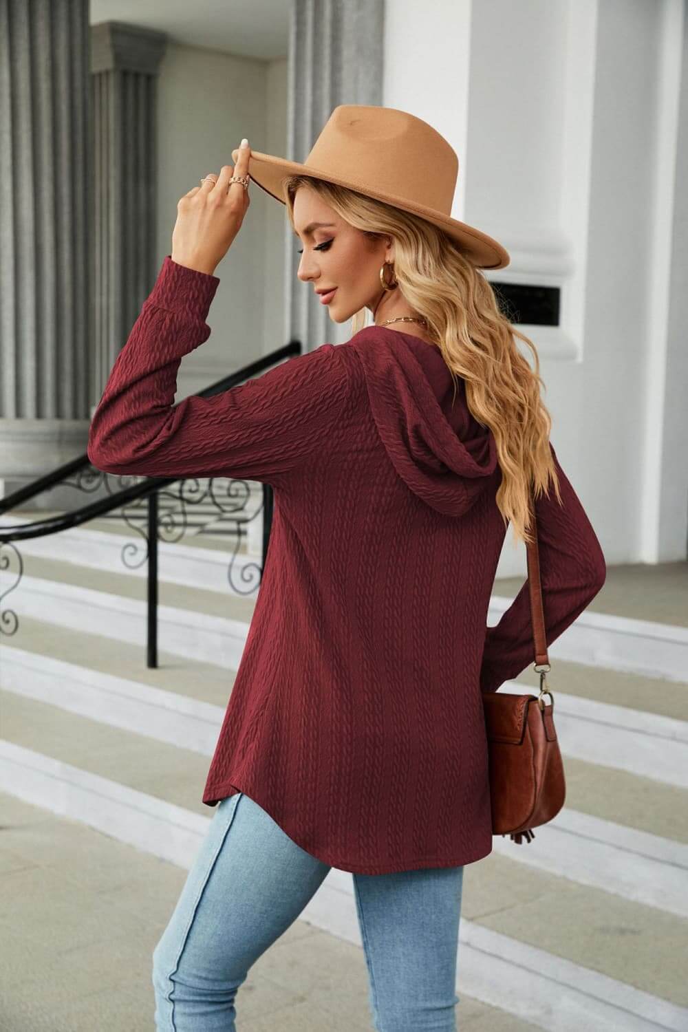 Model wearing Long Sleeve Hooded Blouse in burgundy with a hat, showcasing a cozy casual style.