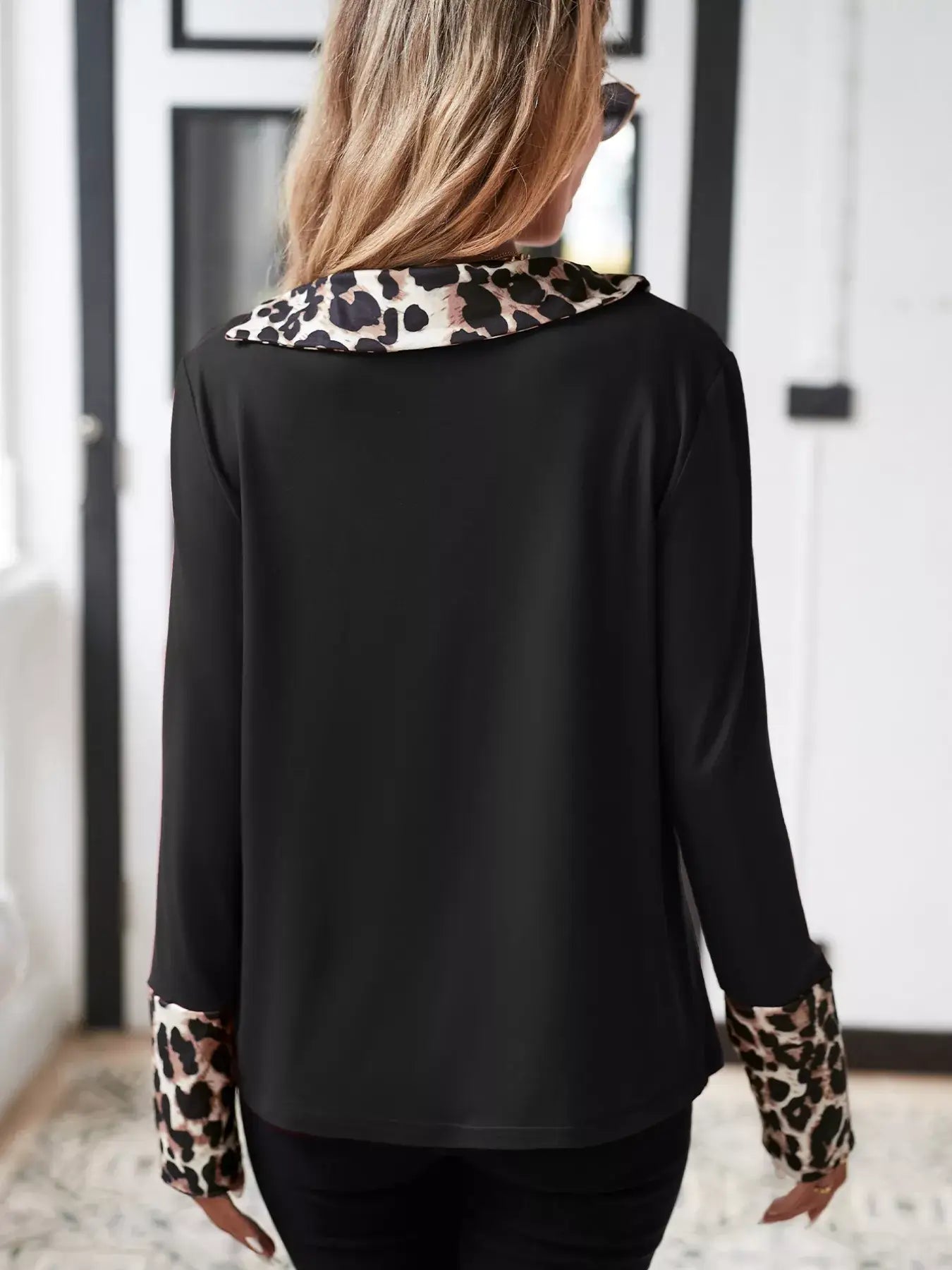 Back view of a stylish leopard long sleeve blouse showcasing chic leopard print details on the collar and sleeves.