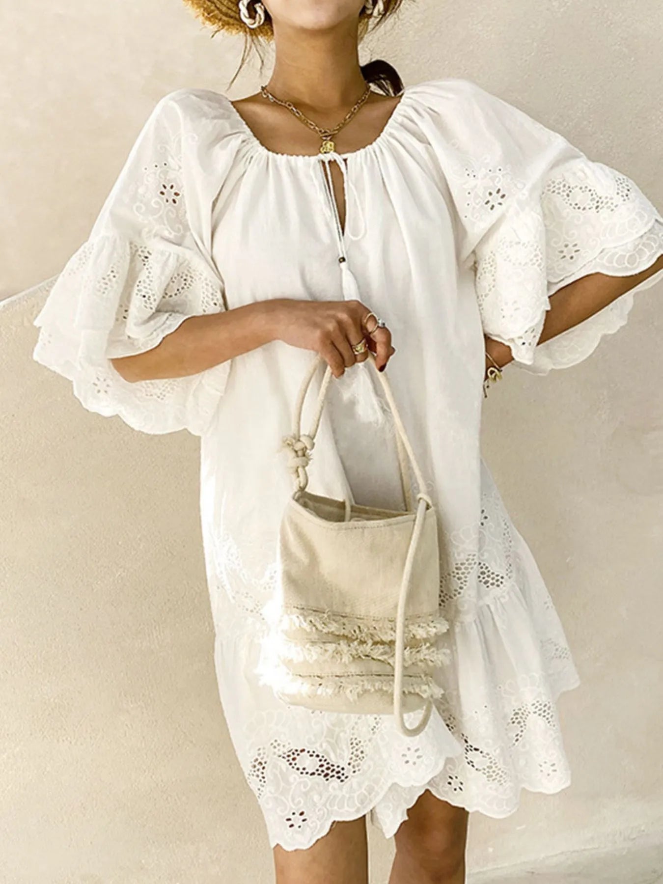 Eyelet Embroidered Tassel Tie Neck Dress worn with stylish bag, showcasing ruffled sleeves and elegant cotton style.