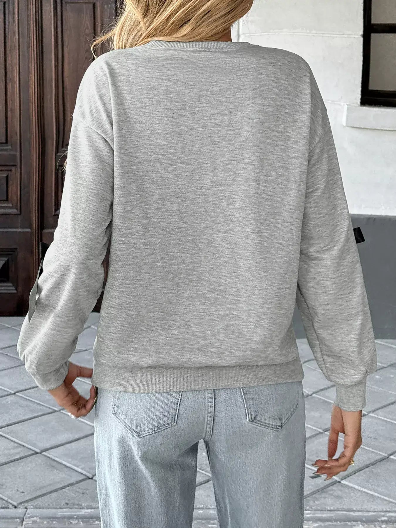 Back view of a Bow Detail Round Neck Sweatshirt in grey, showcasing its relaxed fit and soft texture.