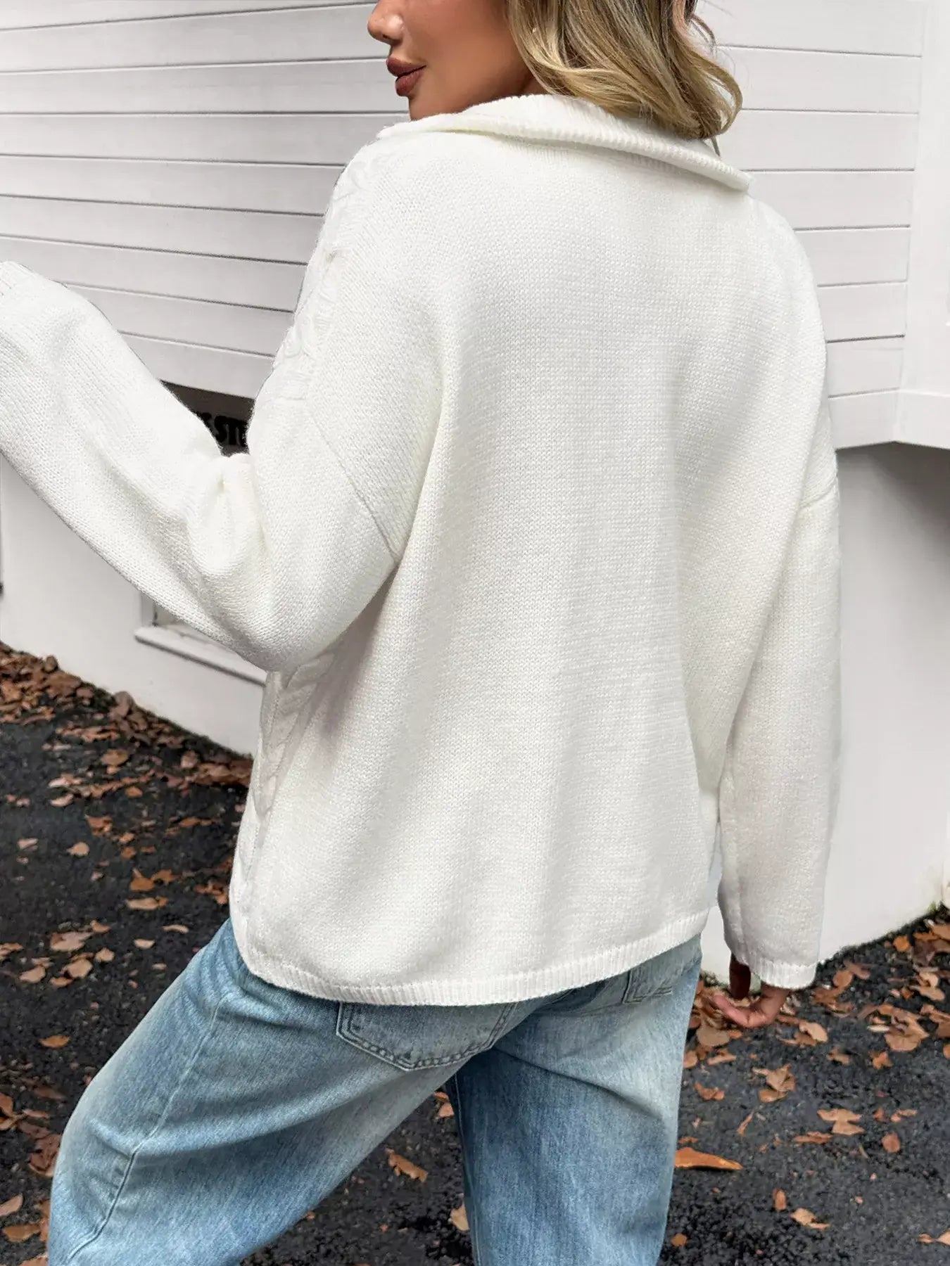 Zip collar cable-knit sweater in white, showcasing a cozy back view with a casual outfit.
