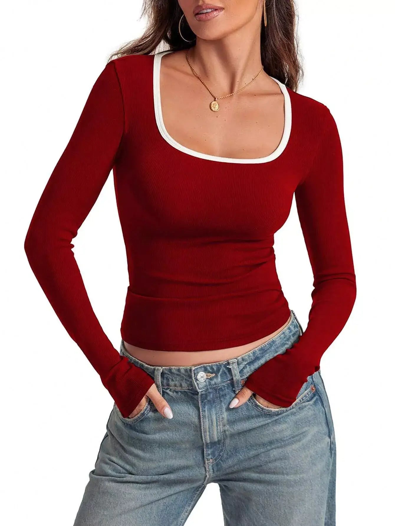 Scoop neck long sleeve t-shirt in red with contrast stitching and fitted design, paired with denim.