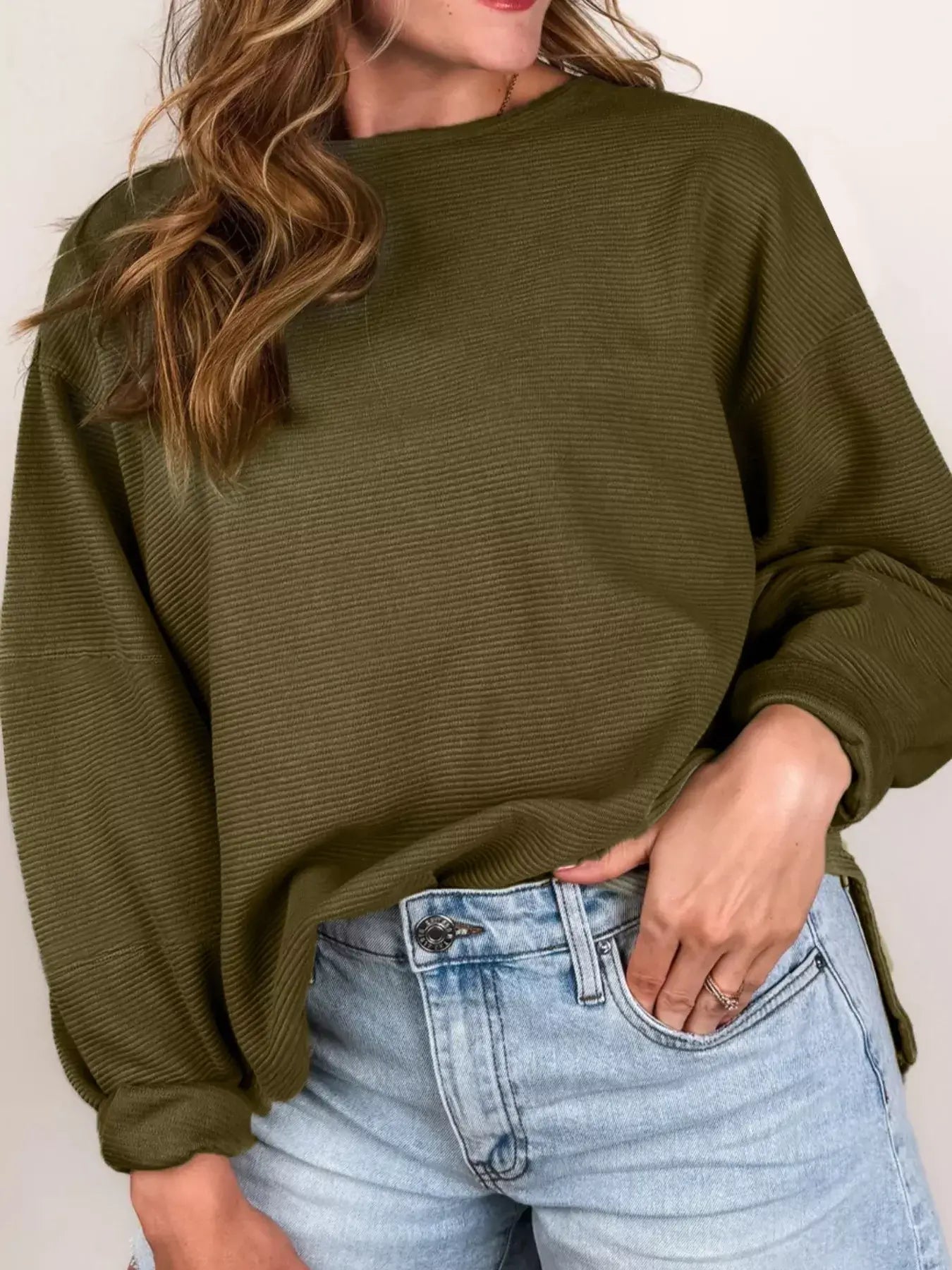 Model wearing a Ribbed Knit Oversized Sweatshirt in olive green, styled with denim shorts for a relaxed look.