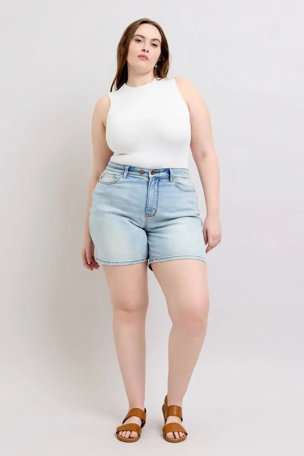 Judy Blue Plus Size Denim Shorts with 2-buttons and pockets, worn by a model in a white top and sandals.