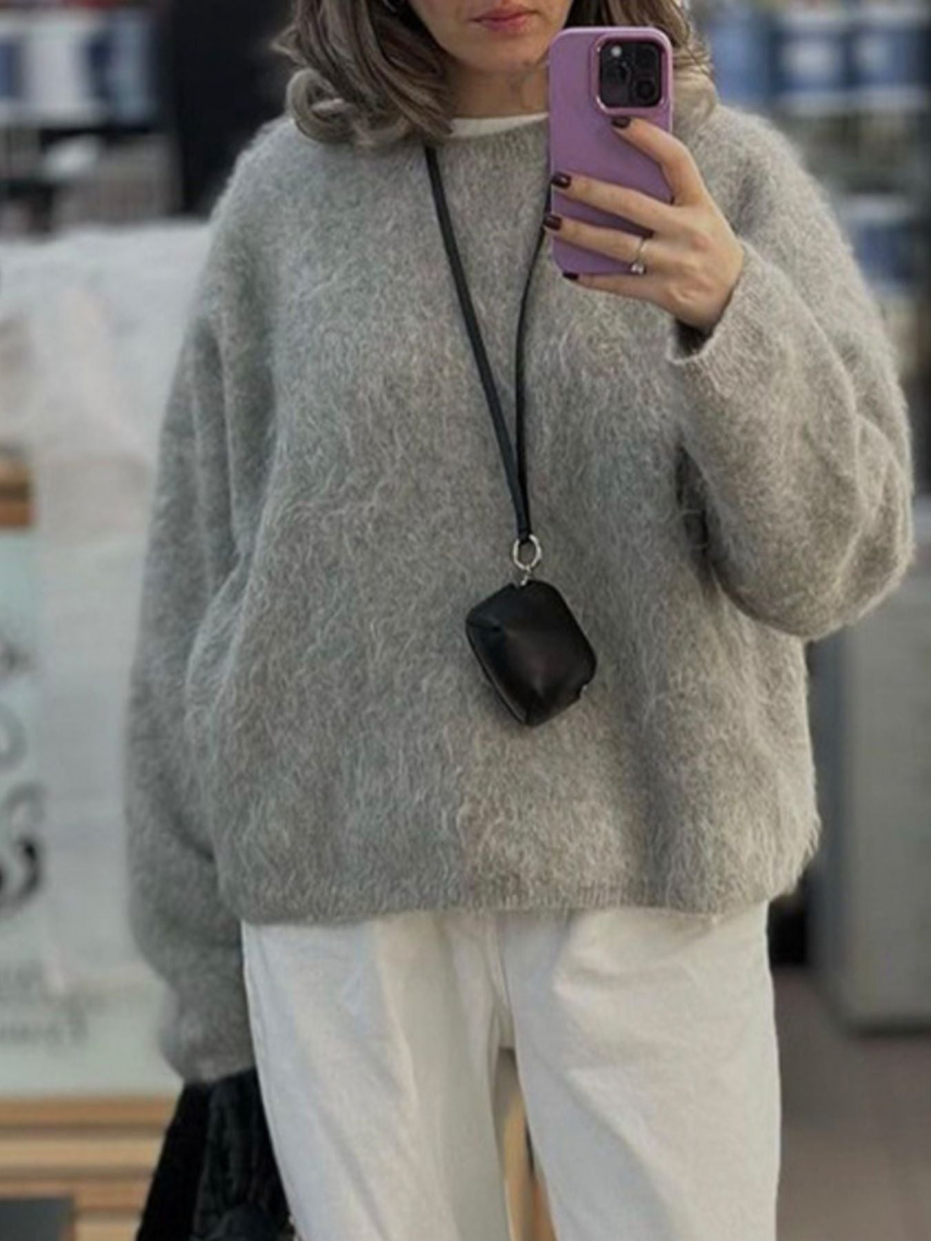 Fuzzy Round Neck Long Sleeve Sweater stylishly worn by a woman, featuring a cozy gray knit texture and relaxed fit.