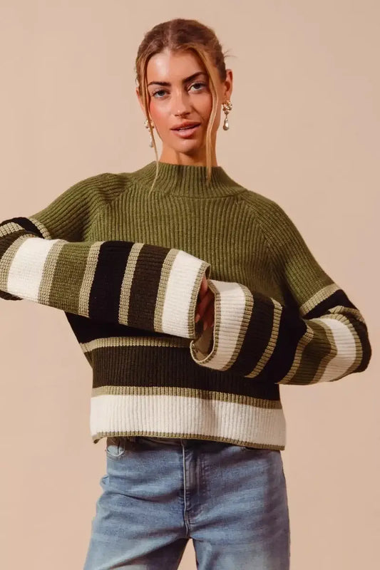 SO ME multi color striped mock neck sweater featuring bold stripes in green and cream, styled with denim jeans.