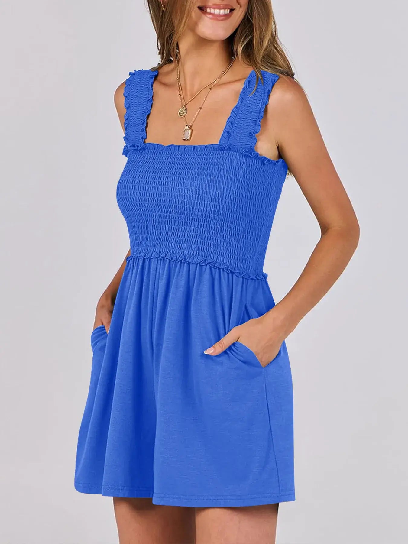 Model wearing a vibrant blue Smocked Square Neck Summer Romper with ruffled straps and pockets.