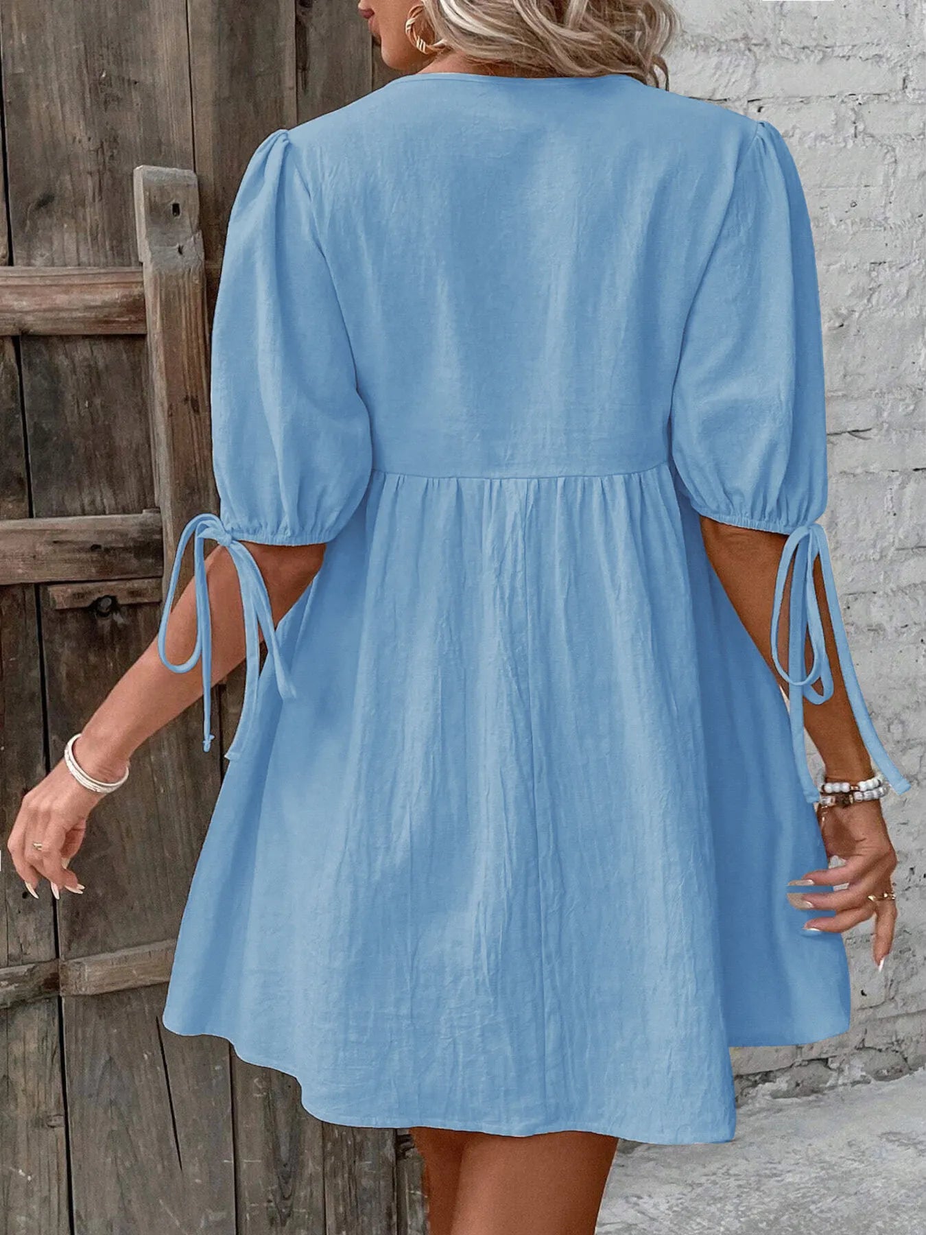 Back view of a V-Neck Tie-Front Mini Dress with Puff Sleeves in light blue, featuring tied sleeves.