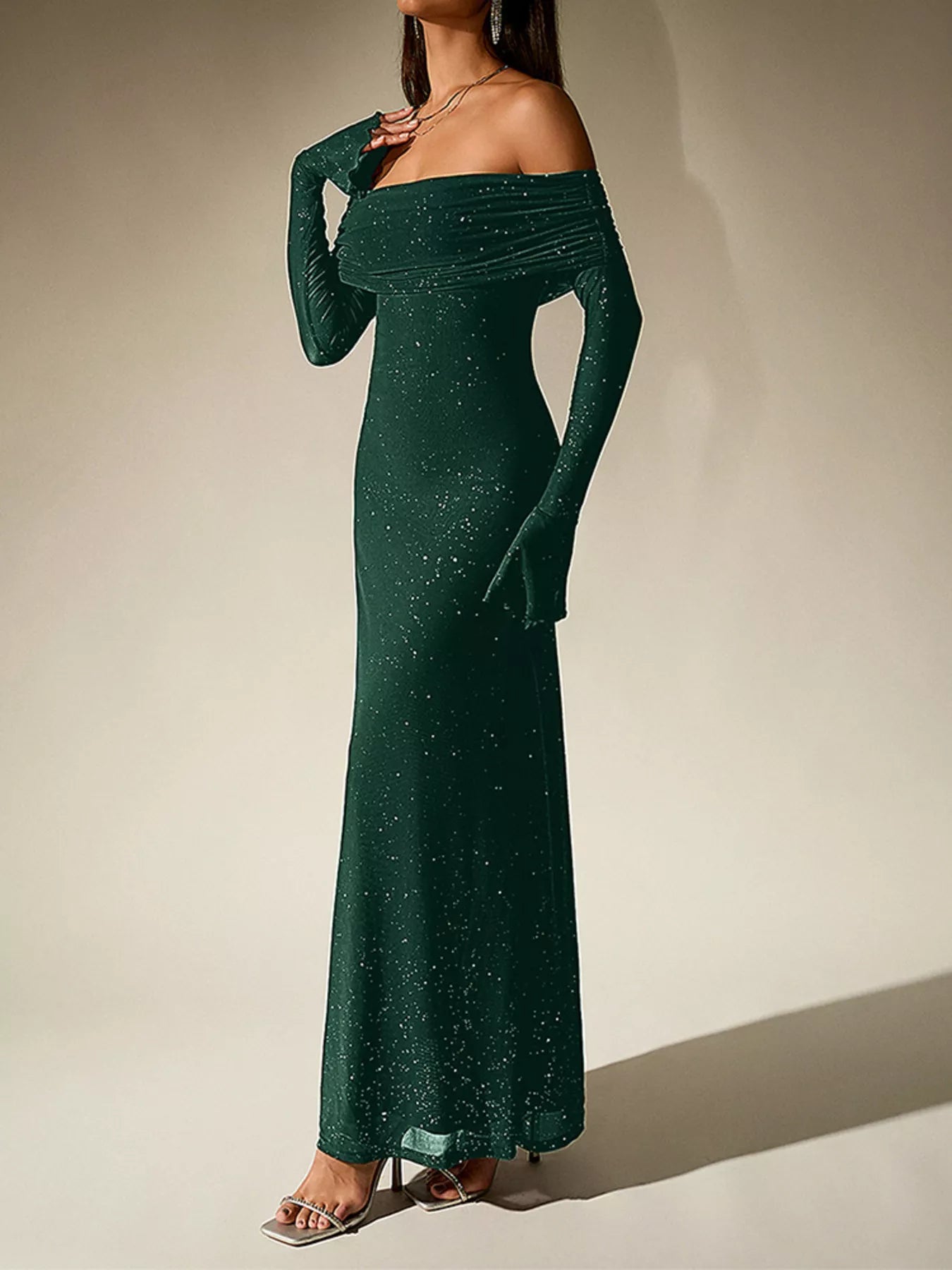 Model showcasing a Glitter Off-Shoulder Maxi Dress, perfect for elegant evening looks, featuring a shimmering design.